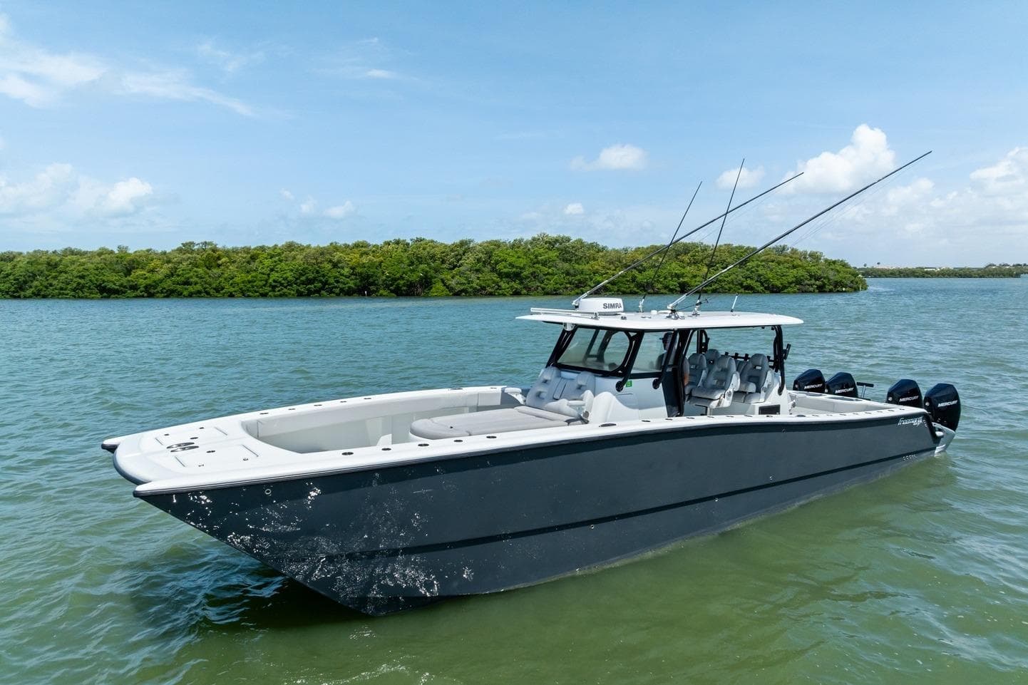 2020 Freeman 42LR boat on calm water with lush green island background.