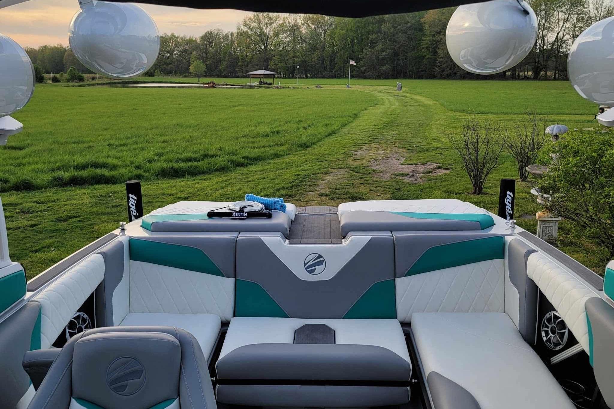 2022 Tigé Z1 boat interior with plush seating, set against a lush green landscape.