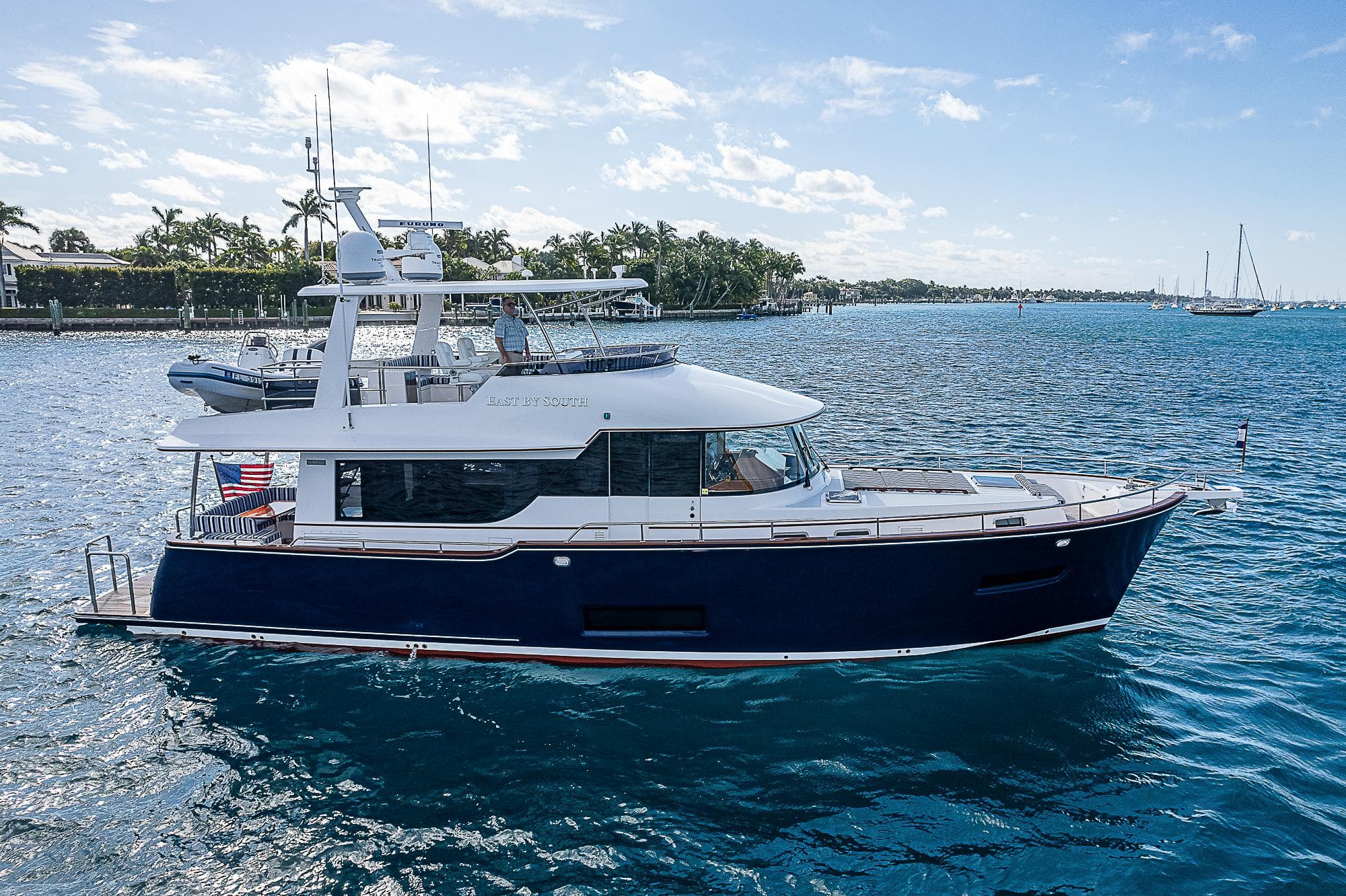 2022 Summit 54 Motoryacht cruising on a sunny day, with clear blue water and sky.