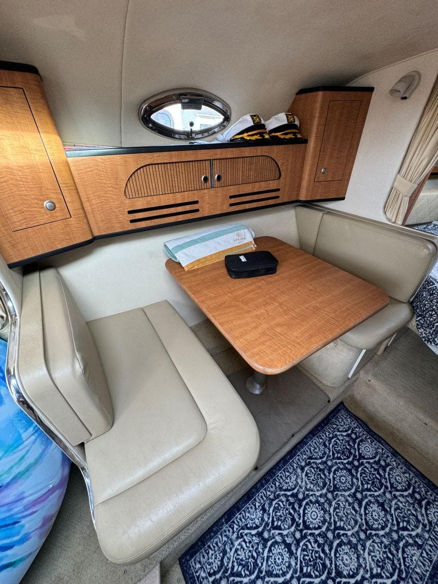 2006 Sea Ray 280 Sundancer cabin with dining area and wooden cabinetry.