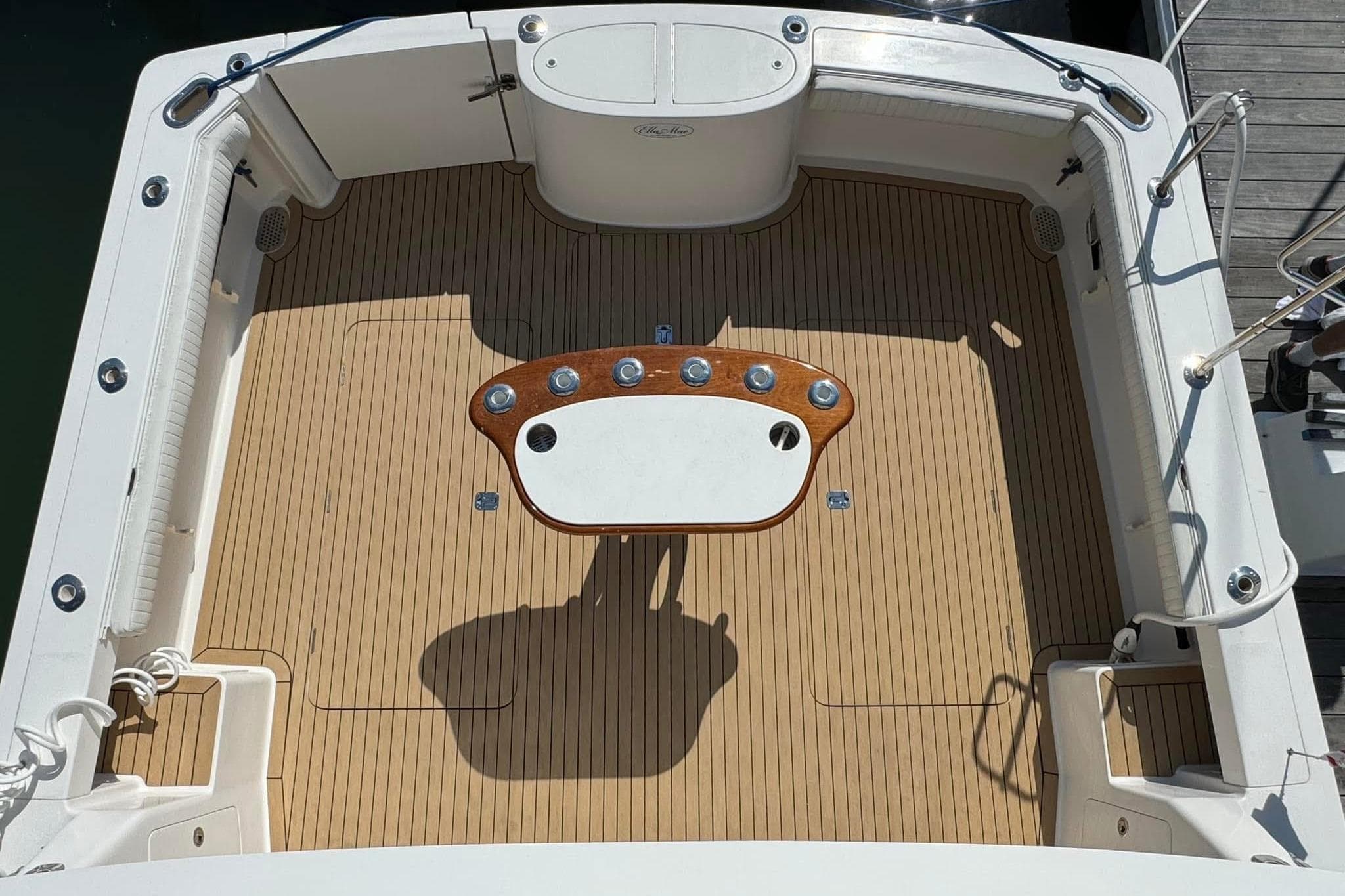Henriques 42 Flybridge 2011 boat deck with wooden flooring and central table.
