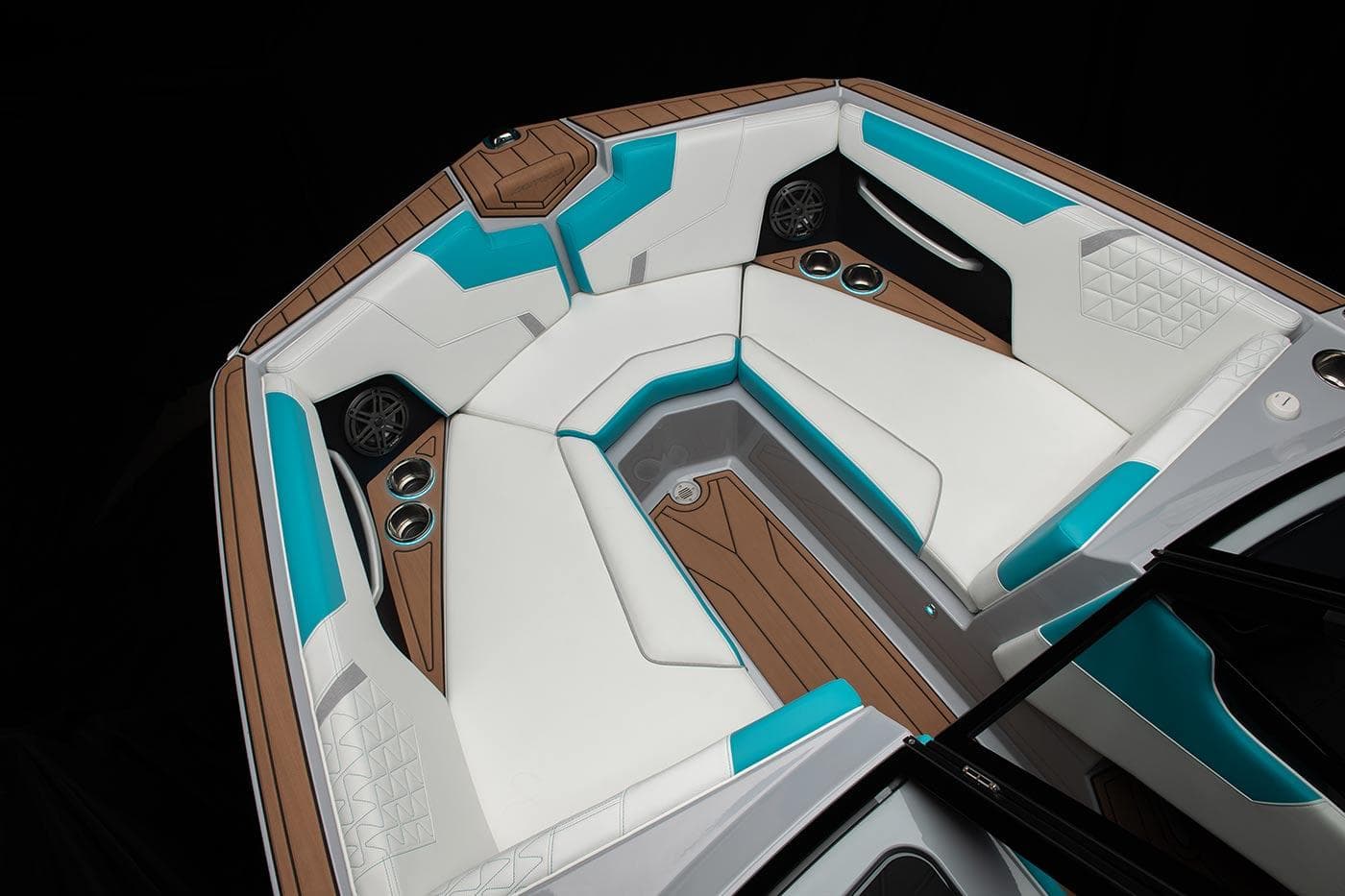 Nautique 2024 GS24 boat interior with white and teal seating, wood accents, and cup holders.