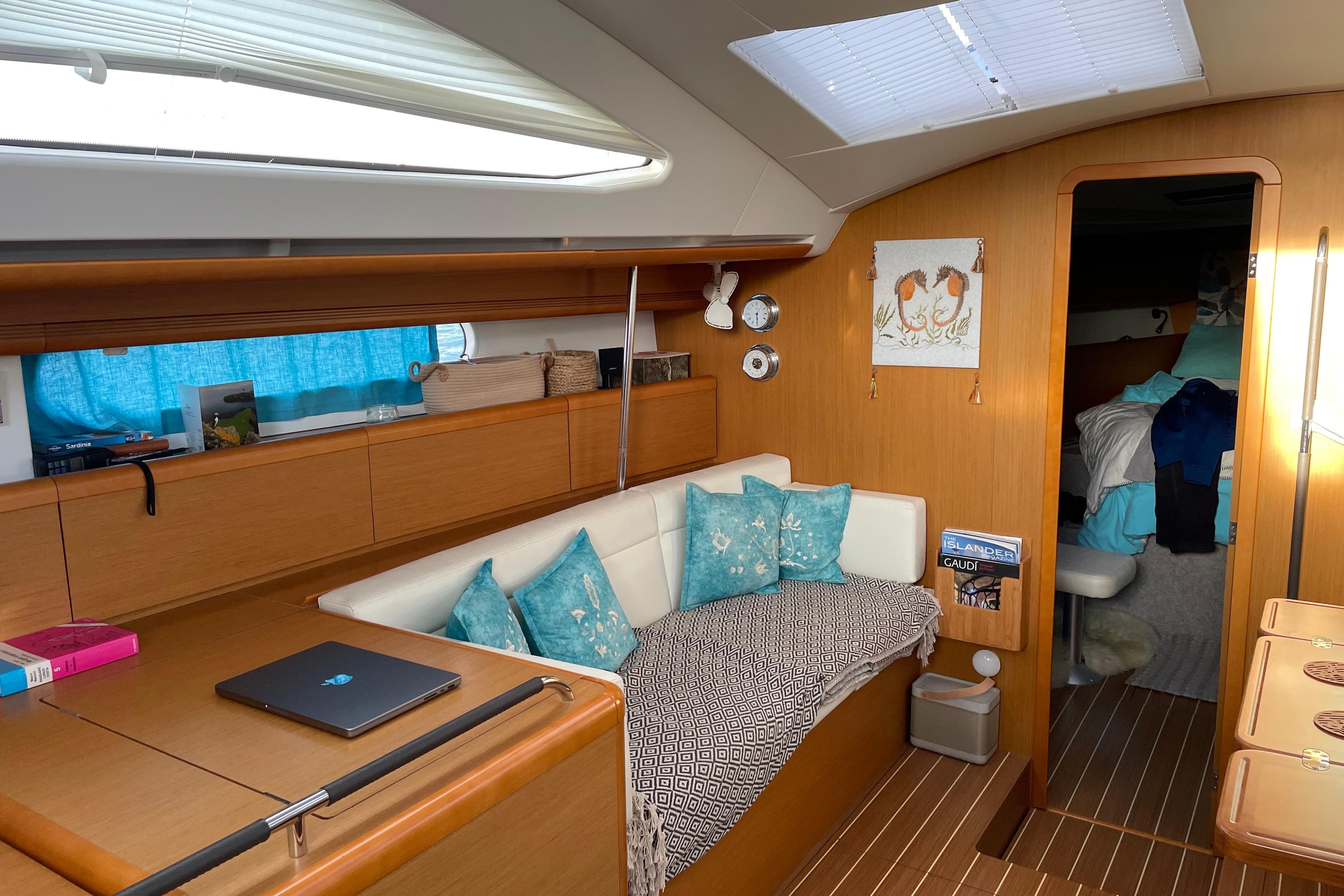 Interior of 2015 Jeanneau Sun Odyssey 50 DS yacht with cozy seating and decor.