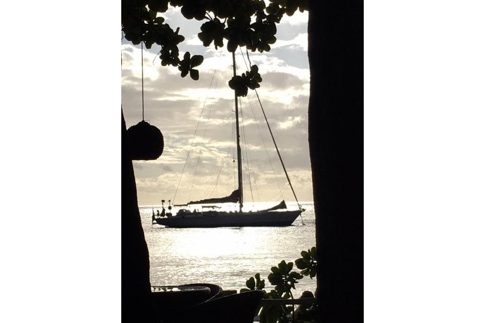 Sailboat silhouette on ocean at sunset, Swan 70 model, 1983.