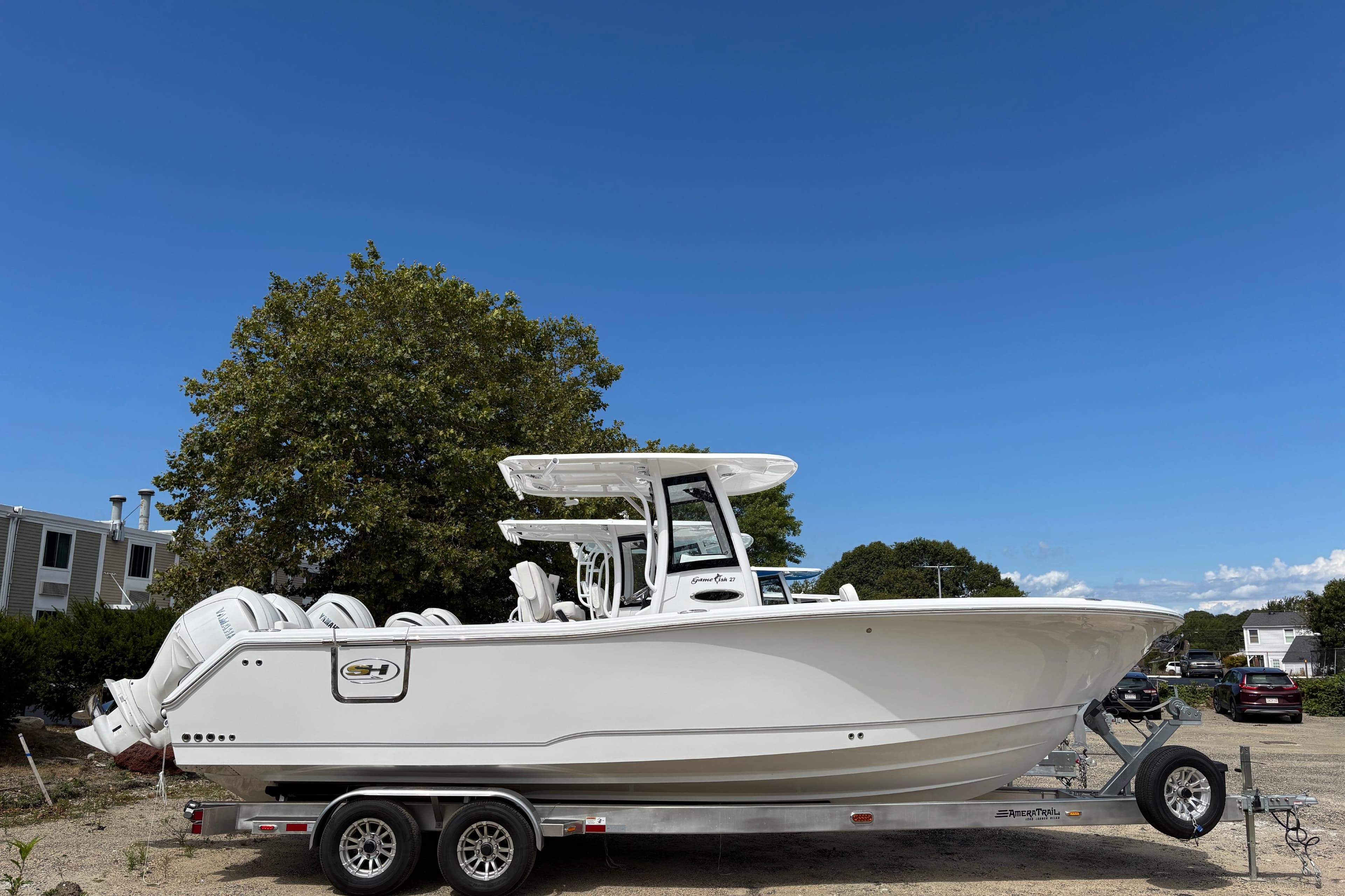 2026 Sea Hunt Gamefish 27 boat on trailer under clear blue sky.