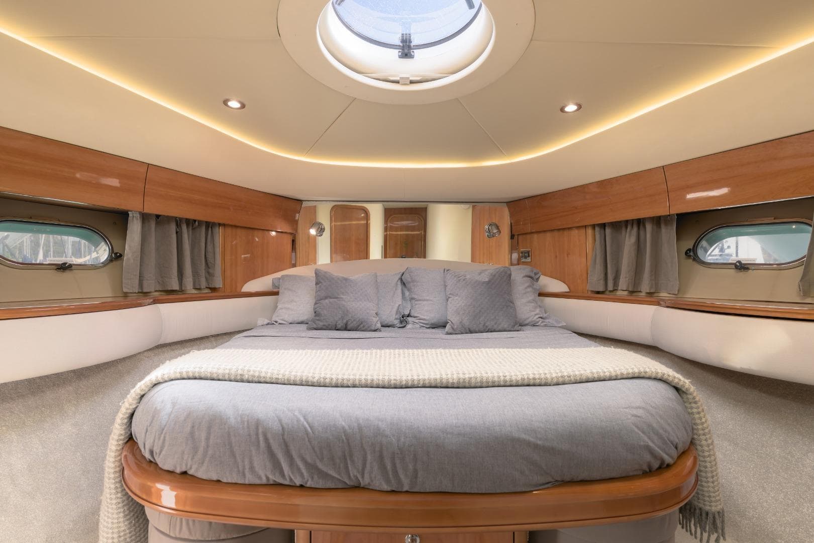 Luxurious cabin interior of 2001 Princess 61 yacht with elegant bedding and wood finishes.