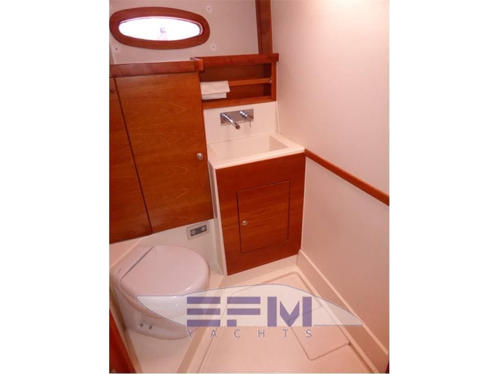 Compact bathroom in 2006 Hanse 531e yacht with wooden cabinetry and modern fixtures.