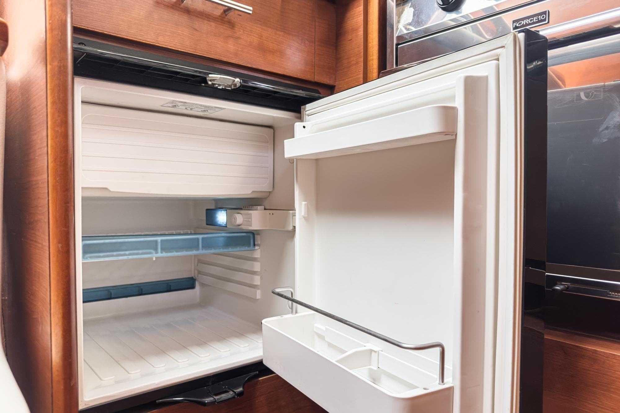 Open refrigerator inside a 2015 Hunter 33 yacht, showcasing interior storage space.
