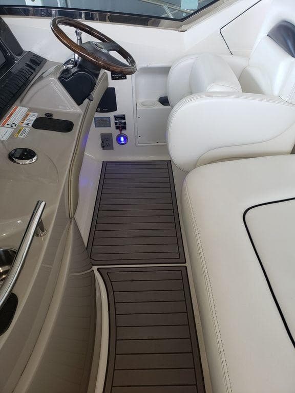 2008 Sea Ray 38 Sundancer helm with white leather seating and wooden steering wheel.