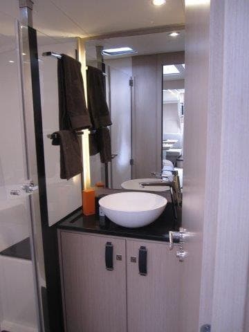 Modern bathroom in 2024 Jeanneau 55 yacht with vessel sink and sleek design.