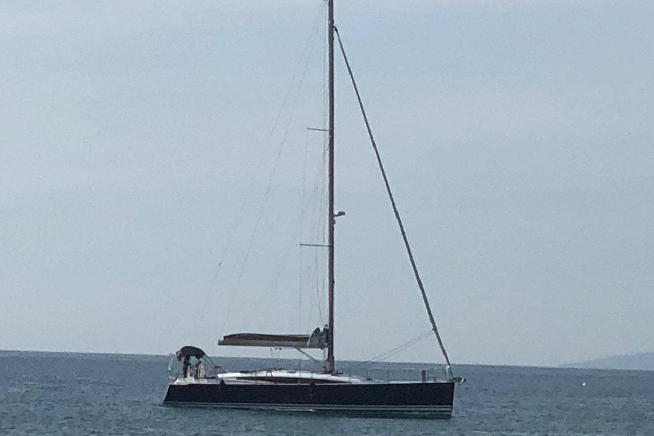 2018 Jeanneau 54 sailboat on calm sea under clear sky.