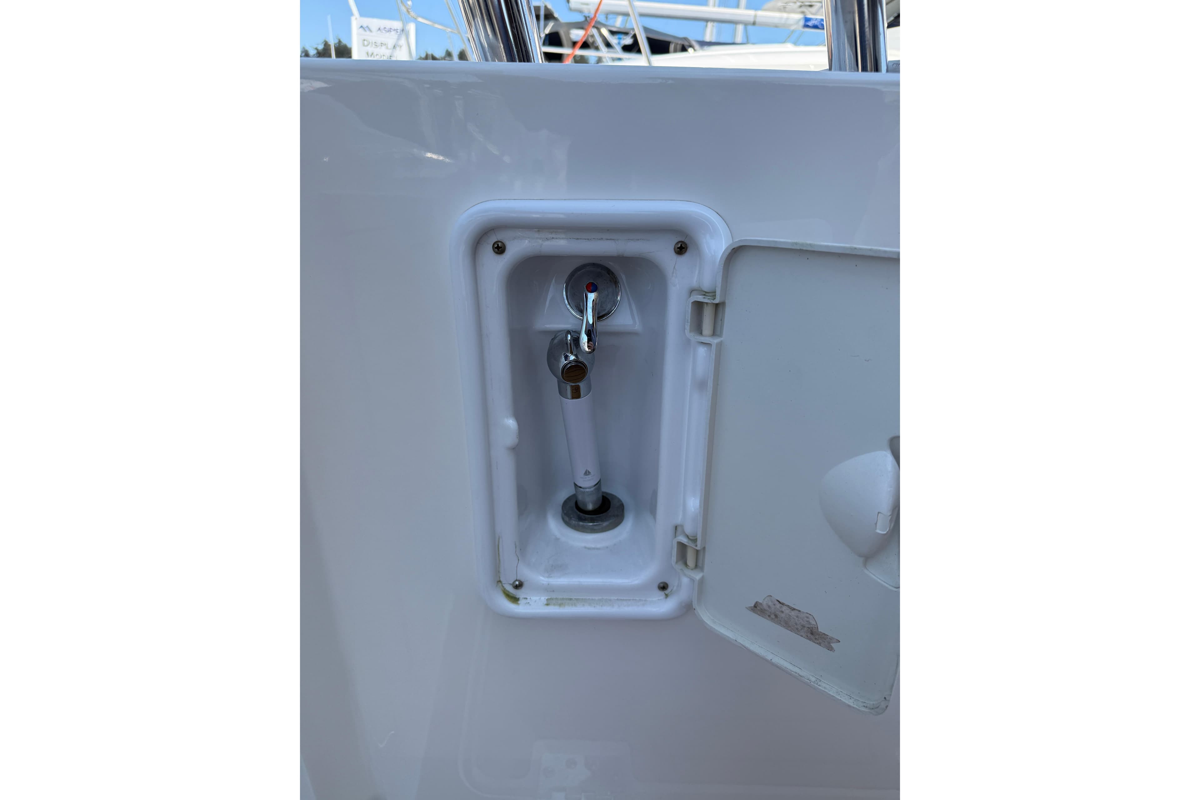 Compartment on Aspen C120 boat, 2017 model, with open hatch and visible faucet.