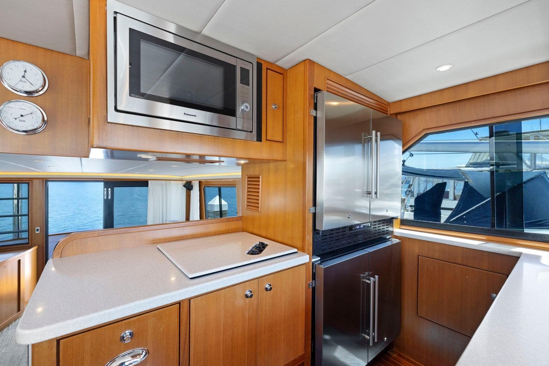 Luxurious yacht kitchen interior with modern appliances, wood cabinetry, and ocean view. Symbol 55, 1999.