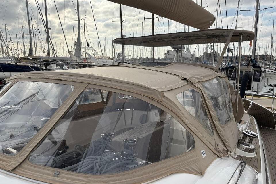 2021 Discovery 58 yacht with beige canopy docked in a marina.