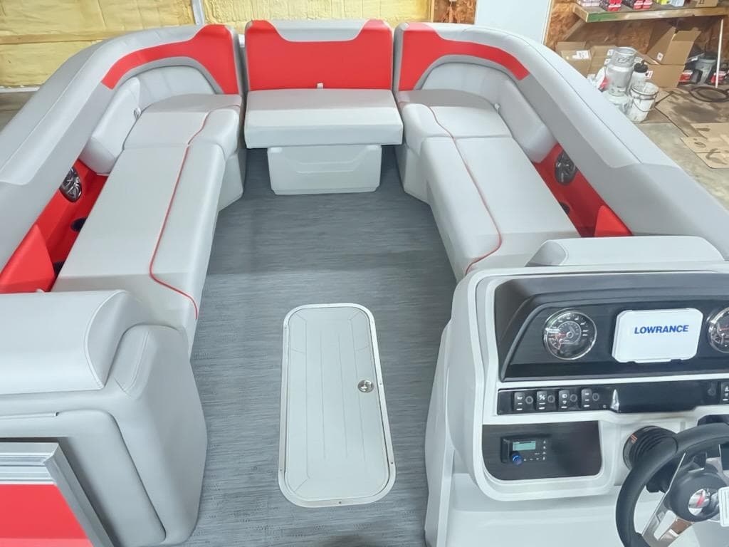 2025 Sweetwater 2286SB pontoon boat interior with red and gray seating and modern dashboard.