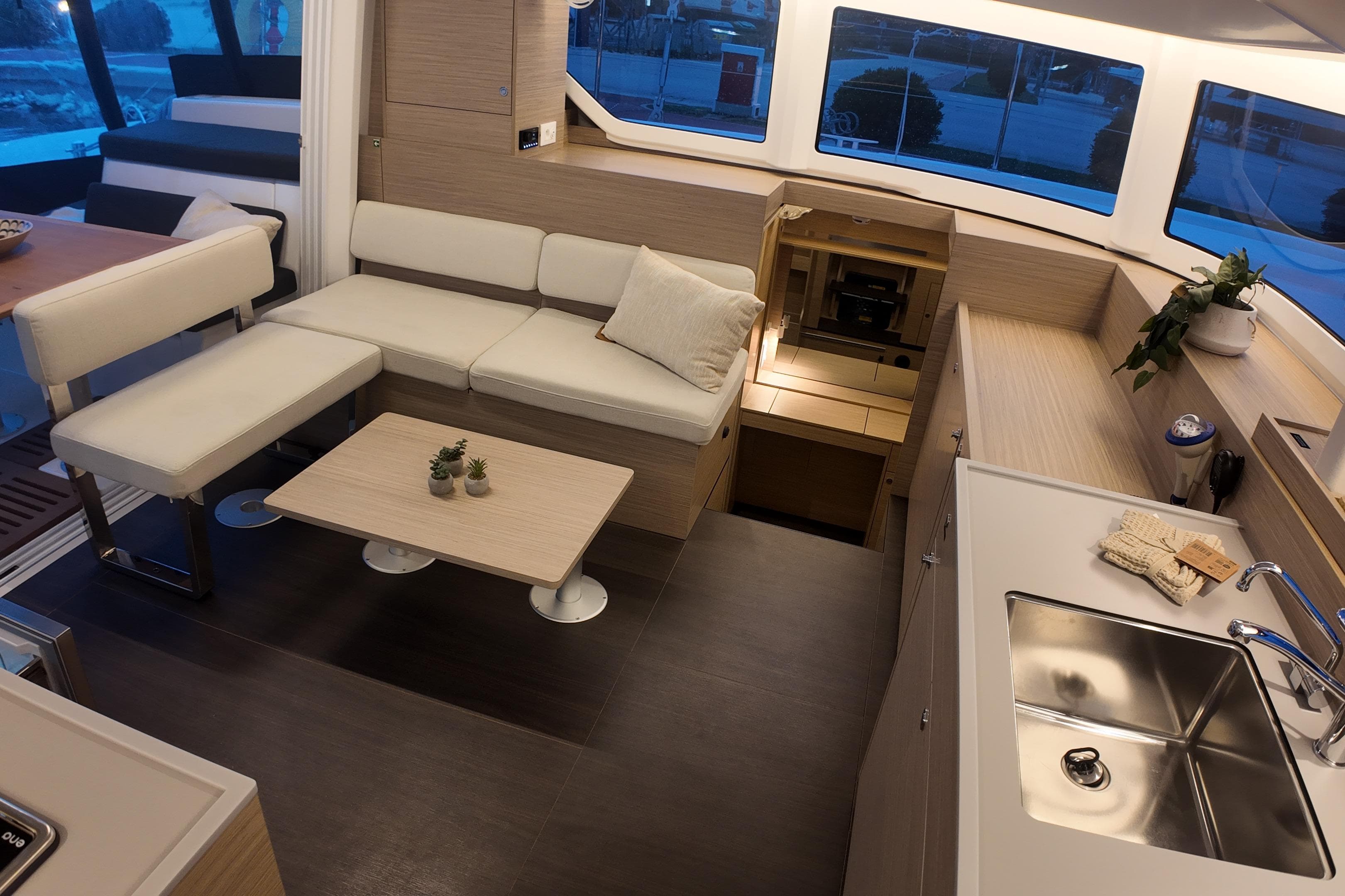 Modern interior of 2026 Lagoon 38 catamaran with sleek kitchen and cozy seating area.