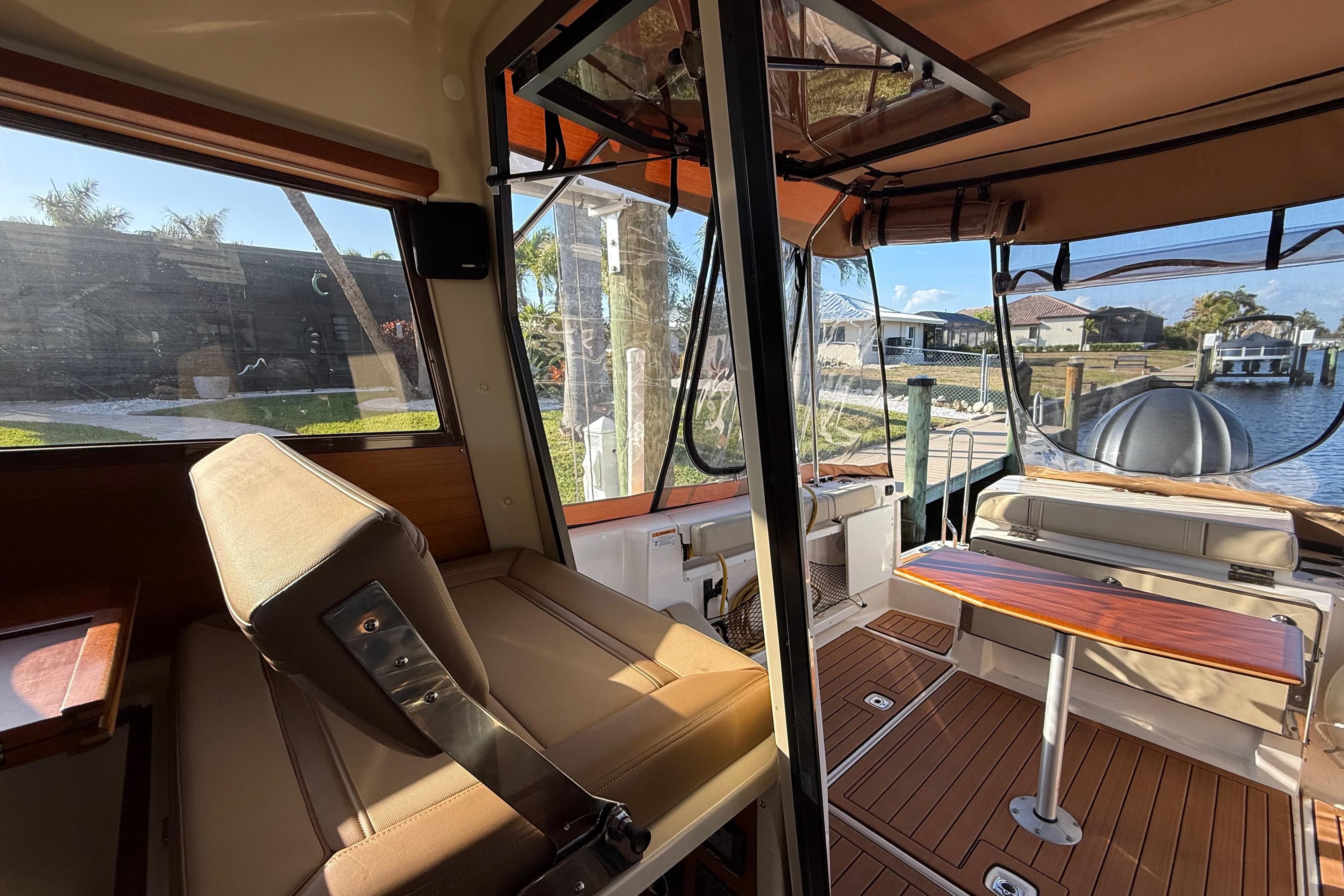 Interior of 2022 Ranger Tugs R-27 boat with seating and table, dockside view.