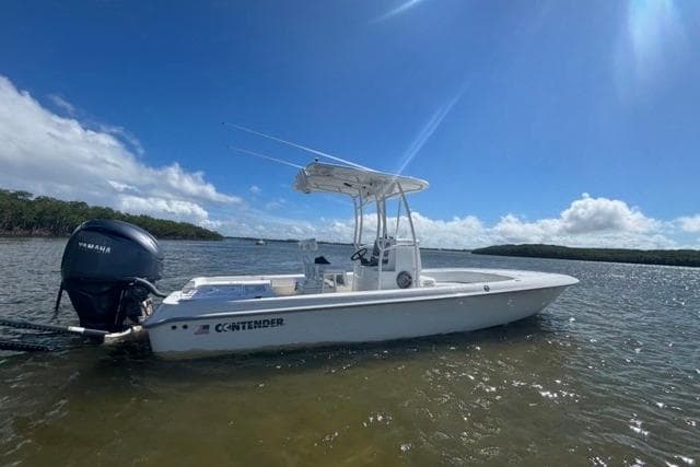 2022 Contender 25 Bay boat on calm water under clear blue sky.
