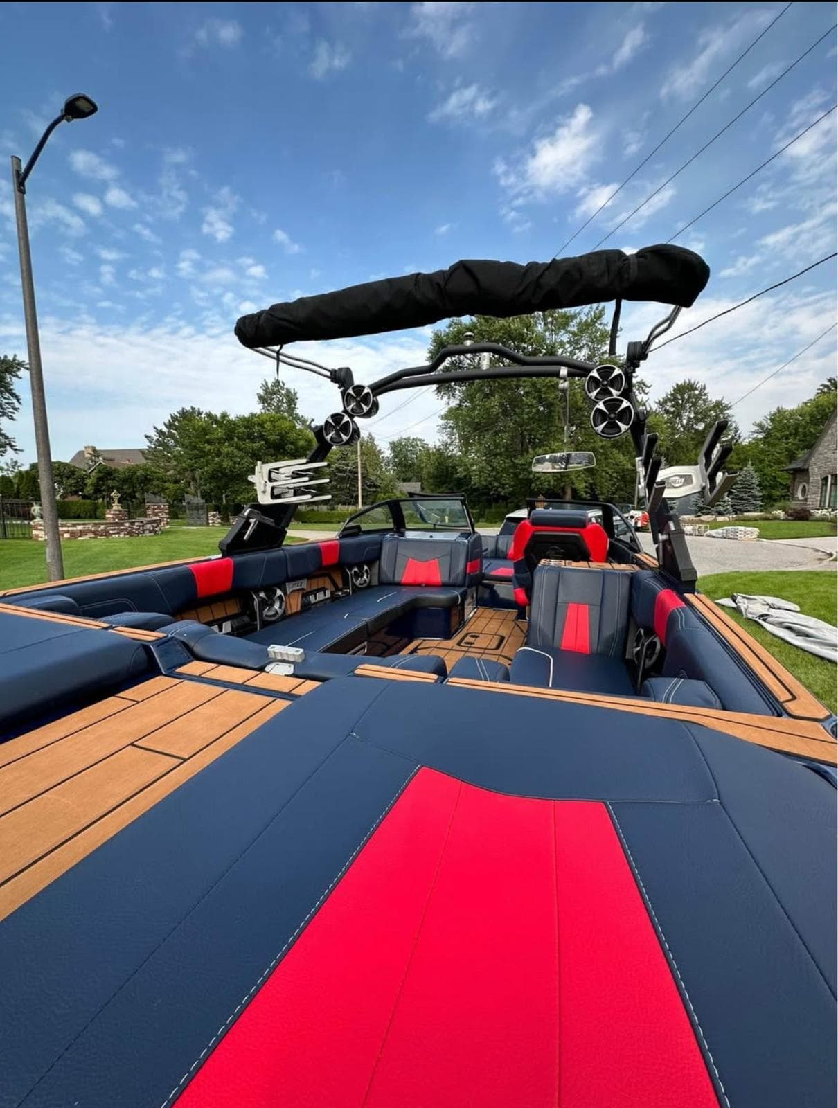 2021 Malibu Wakesetter 24 MXZ boat with red and blue interior, parked outdoors.