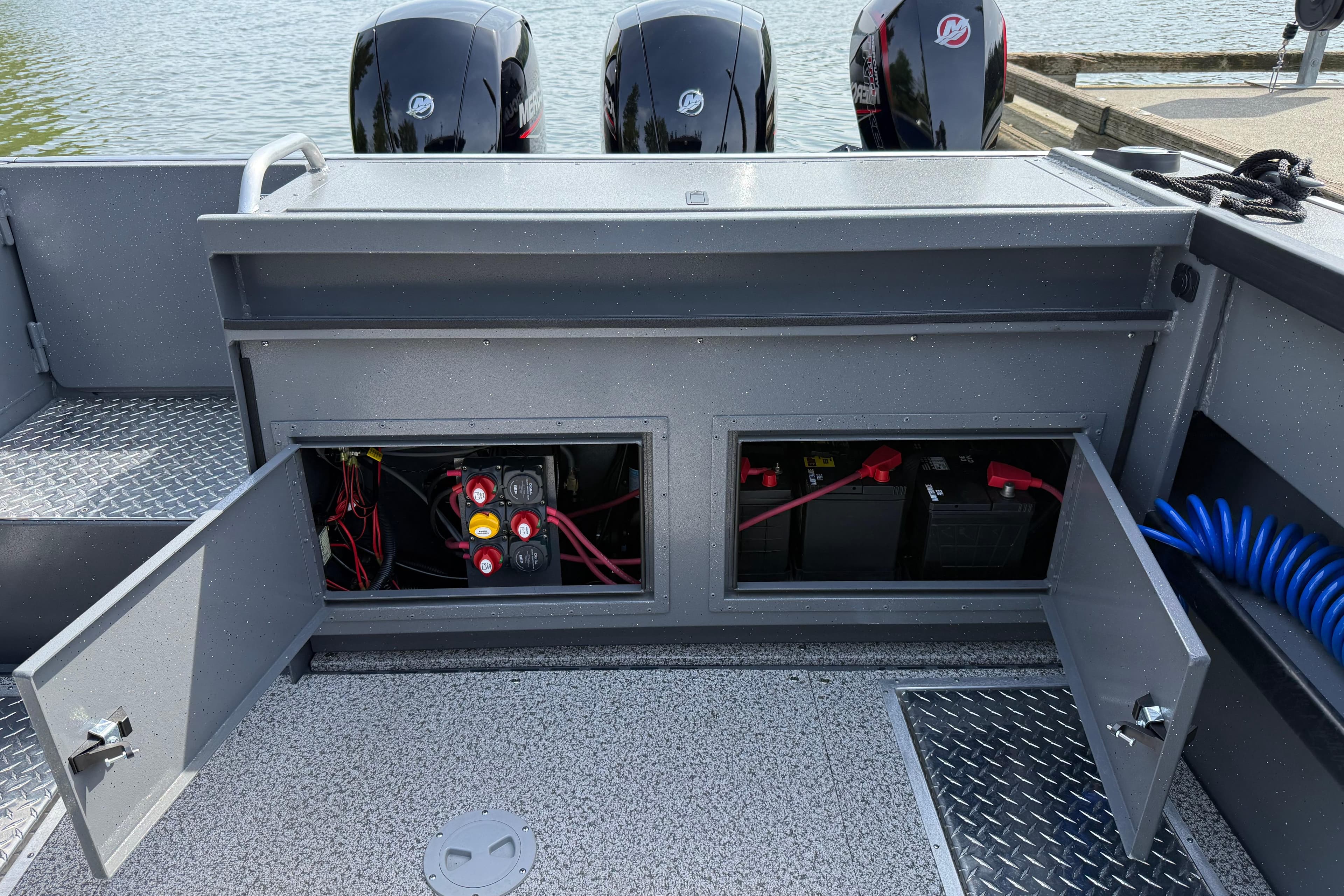 Alumaweld Horizon 26 boat, 2026 model, showing open battery compartment and dual Mercury engines.