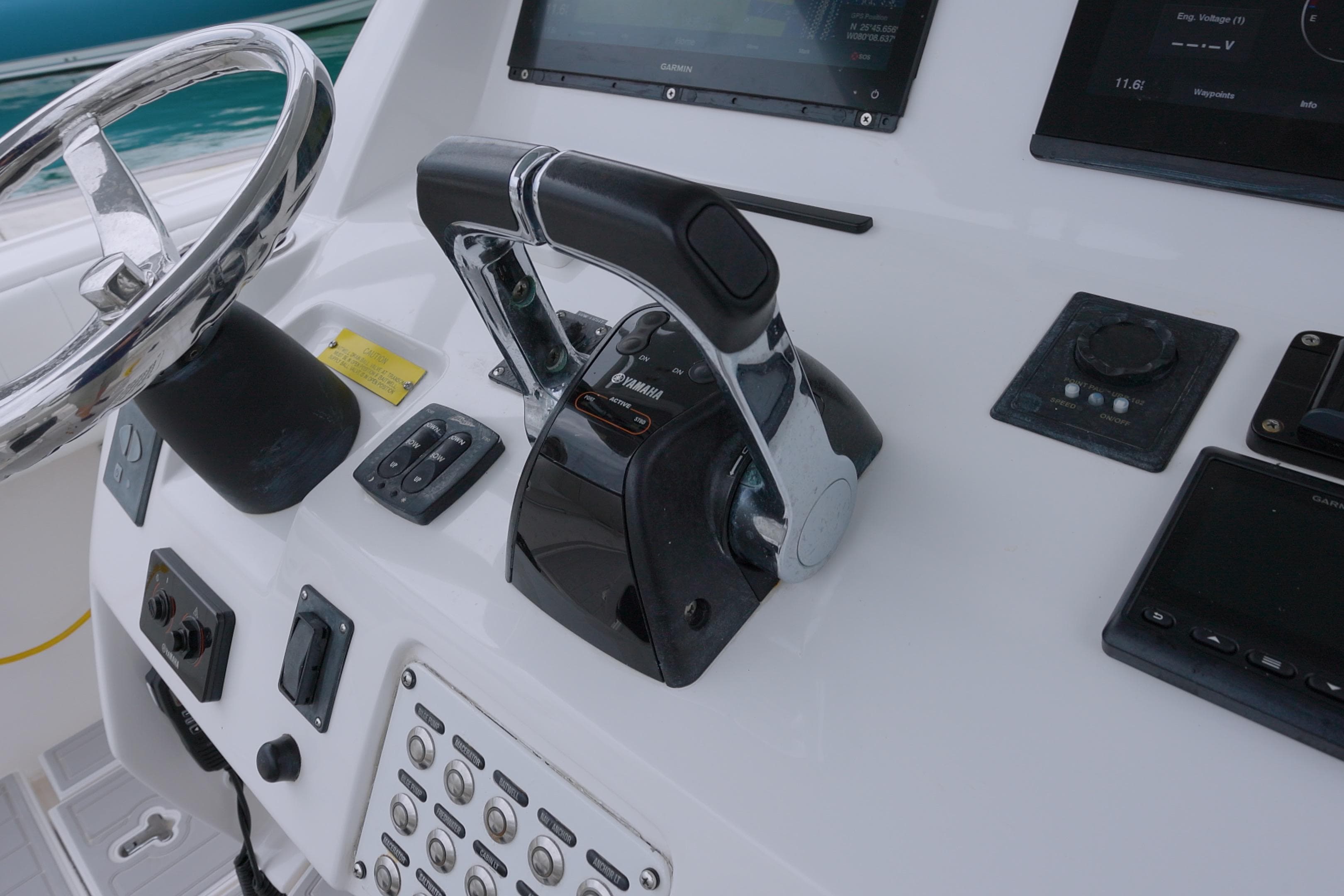 Control panel of a 2014 Intrepid 327 Cuddy boat with steering wheel and throttle.