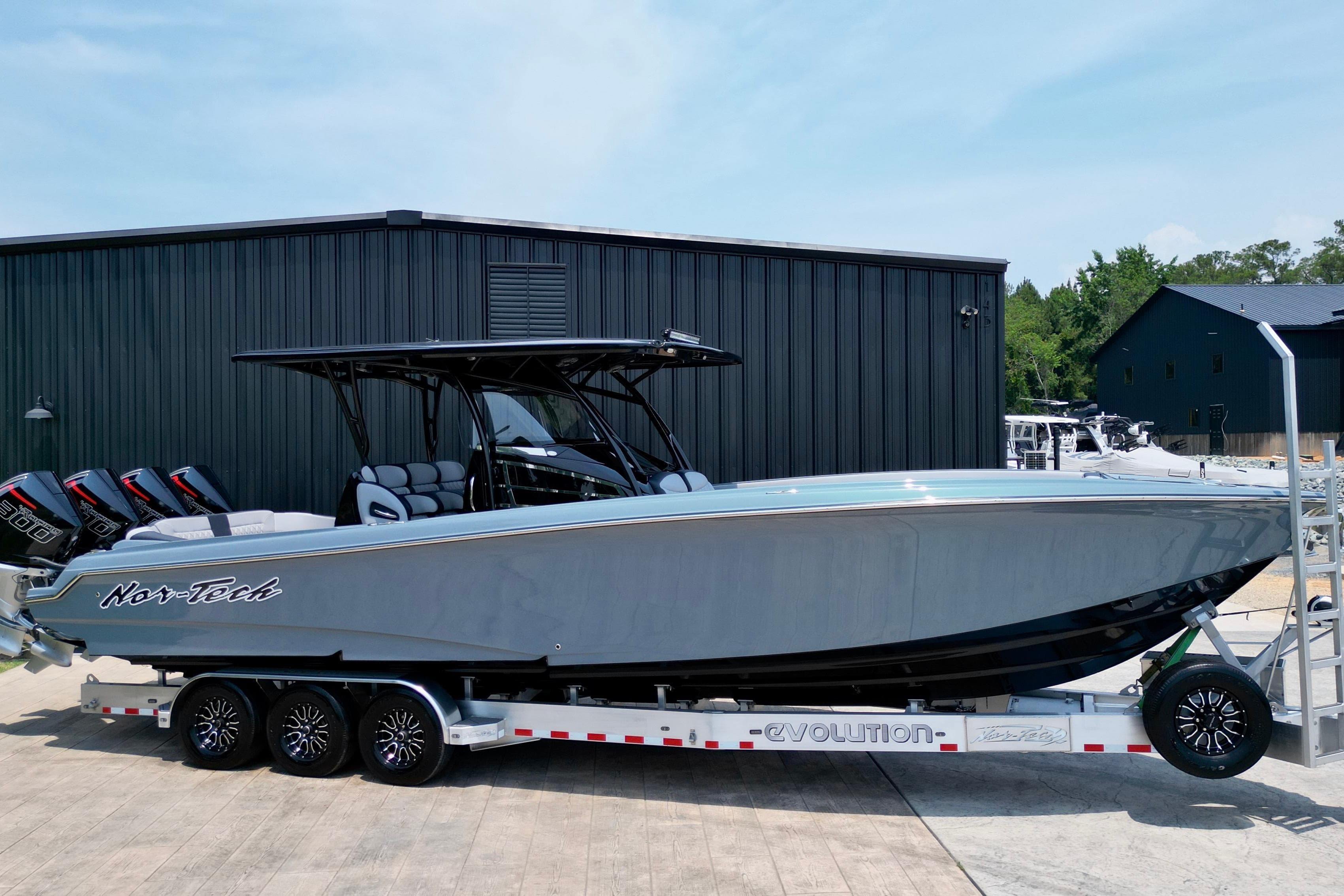 2025 Nor-Tech 340 Sport Center Console boat on trailer, sleek design, triple engines.