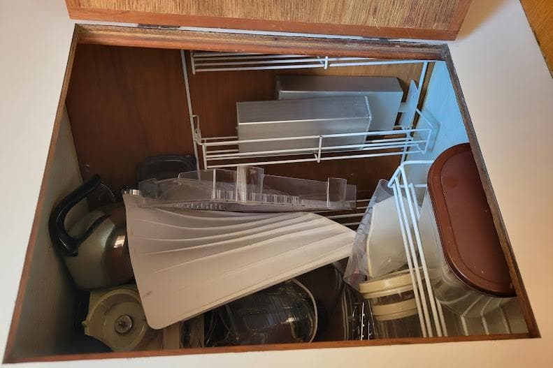 Storage compartment on 1988 Freedom Yachts FREEDOM 36, containing kitchen items and utensils.