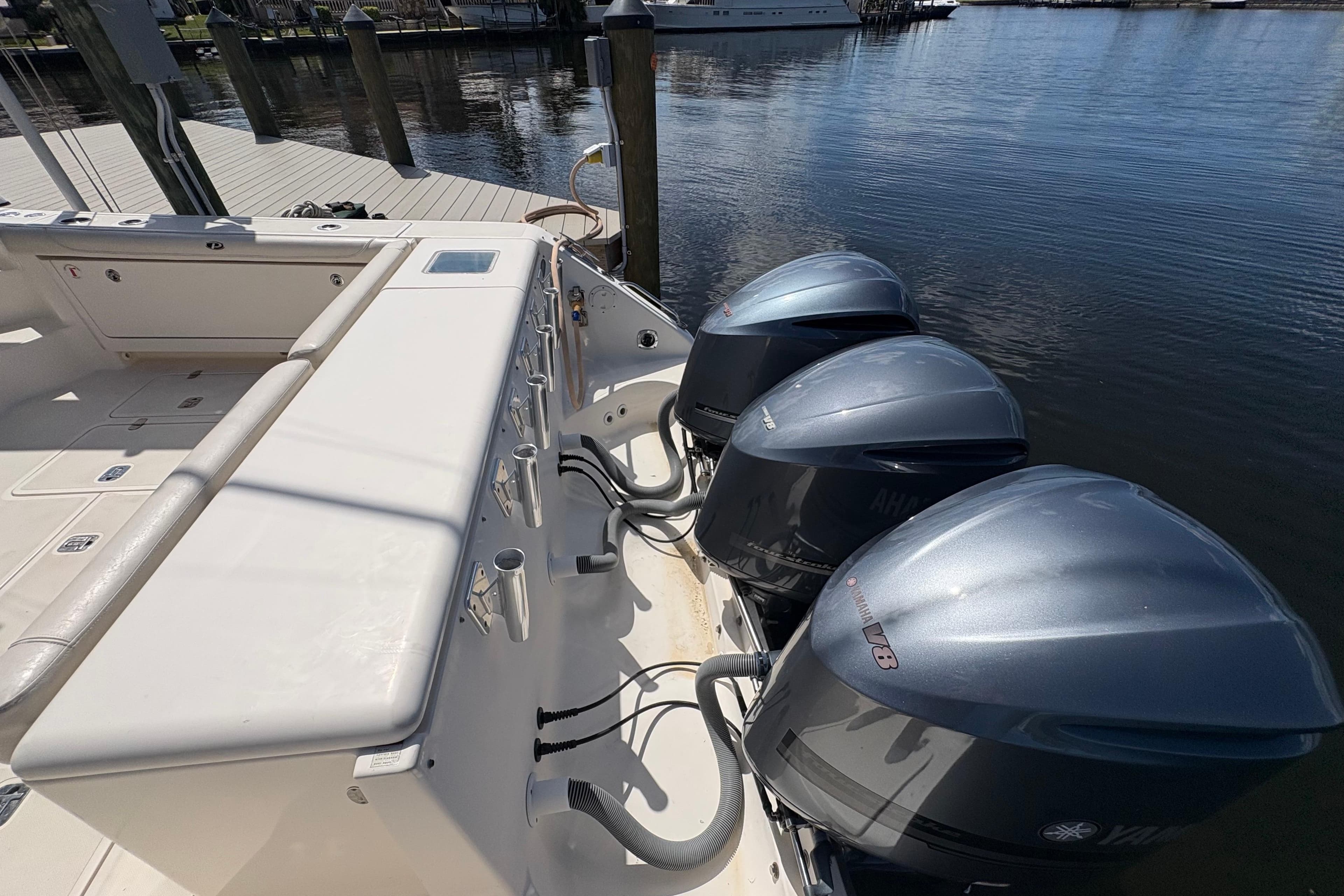 2011 Pursuit OS 375 Offshore boat with triple Yamaha V8 engines docked by the water.