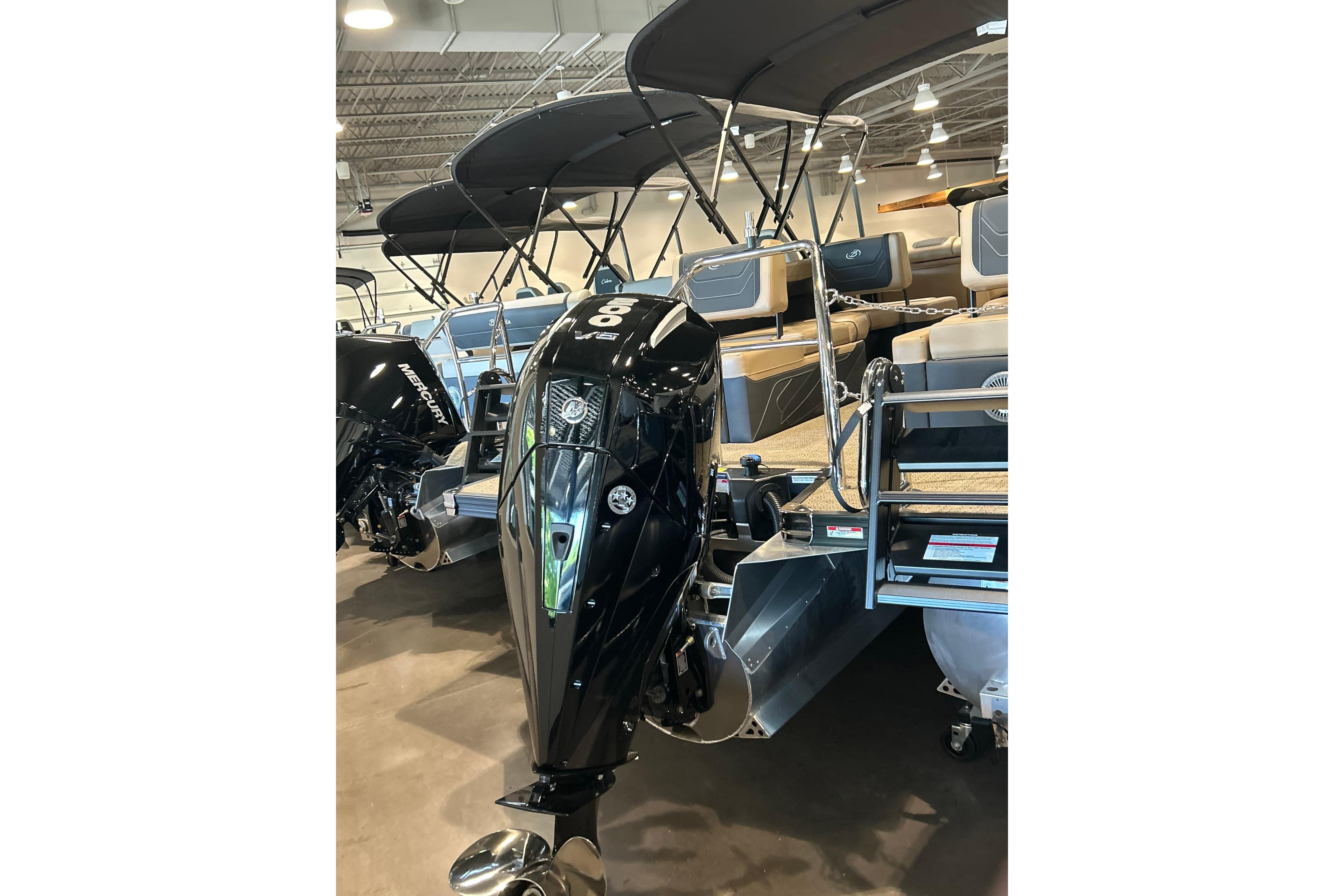 2026 Barletta Cabrio 22M pontoon boat with Mercury outboard motor in showroom.