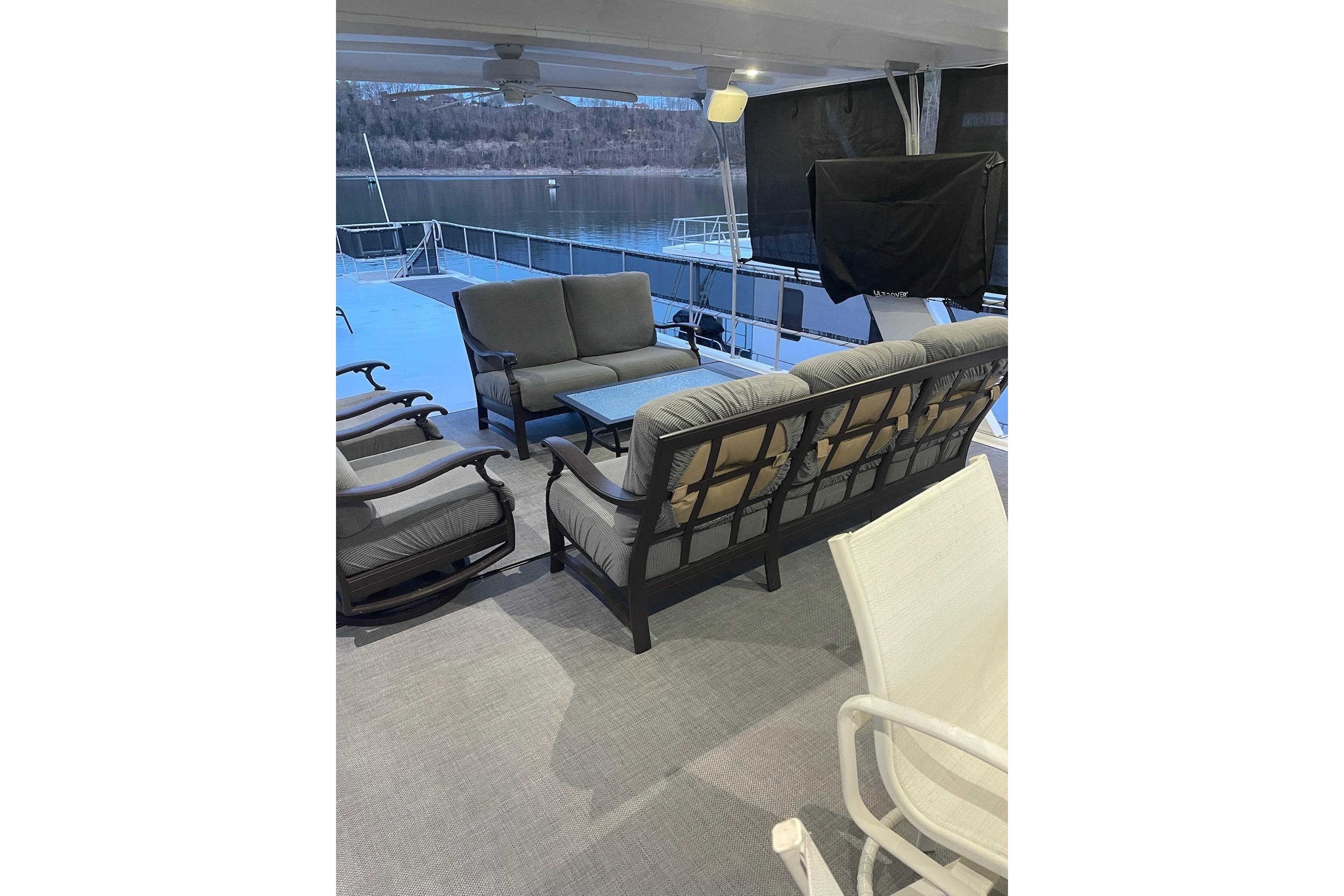 Outdoor seating area on 2001 Sumerset 16x79 houseboat with lake view.