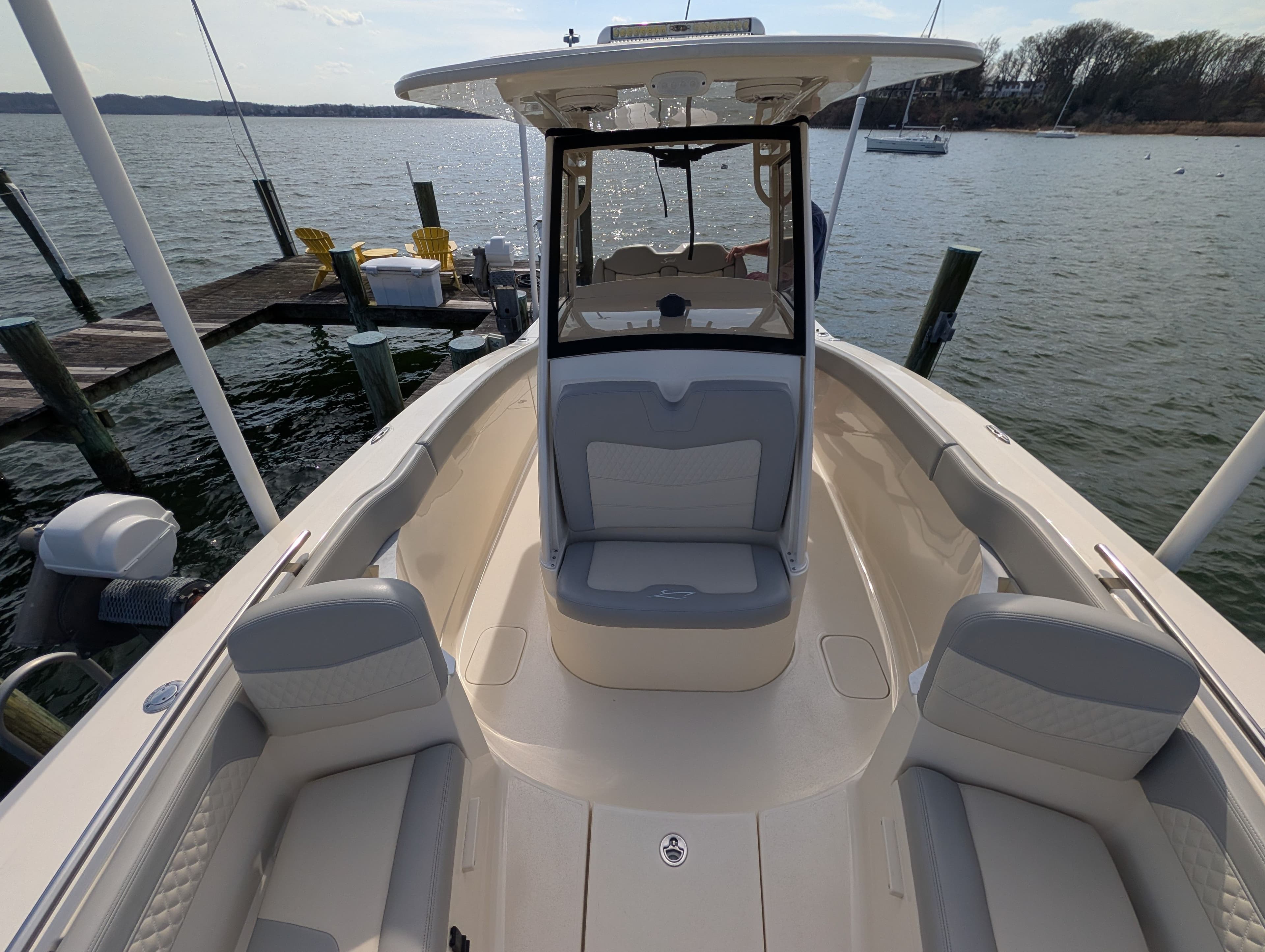 2024 Scout 277 LXF boat at dock with seating area.