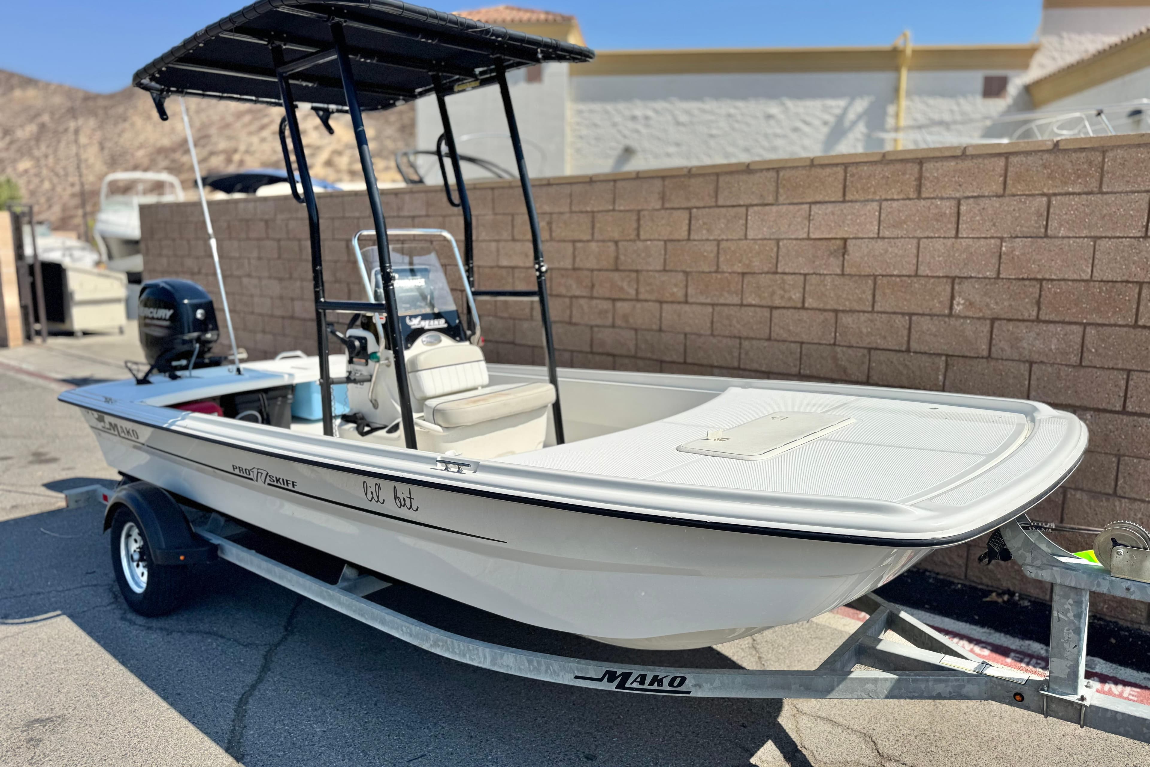 2017 Mako Pro Skiff 17 CC boat on trailer, parked outdoors.