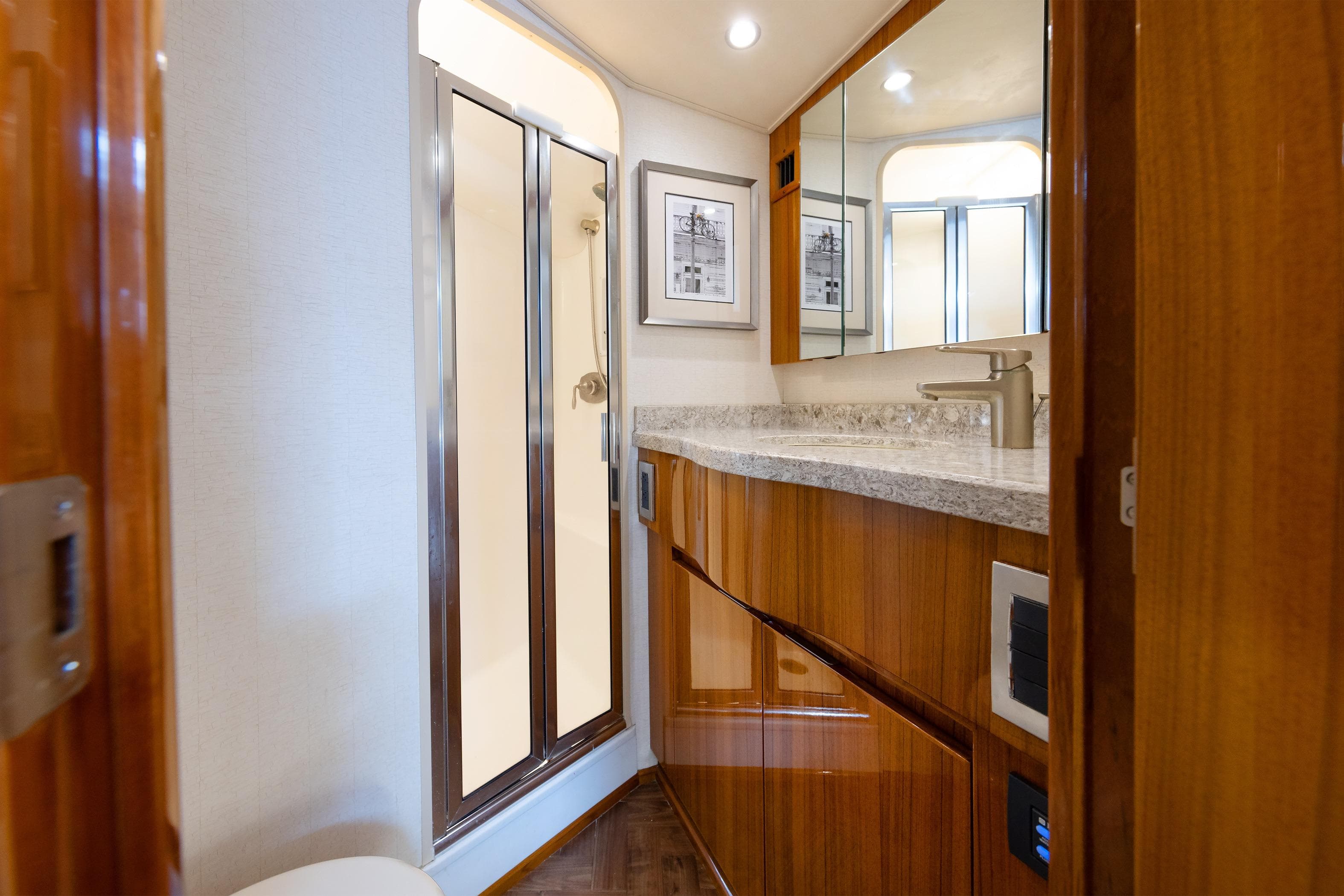 Luxurious bathroom interior of 2017 Viking 52 Sport Tower yacht with wood cabinetry and modern fixtures.