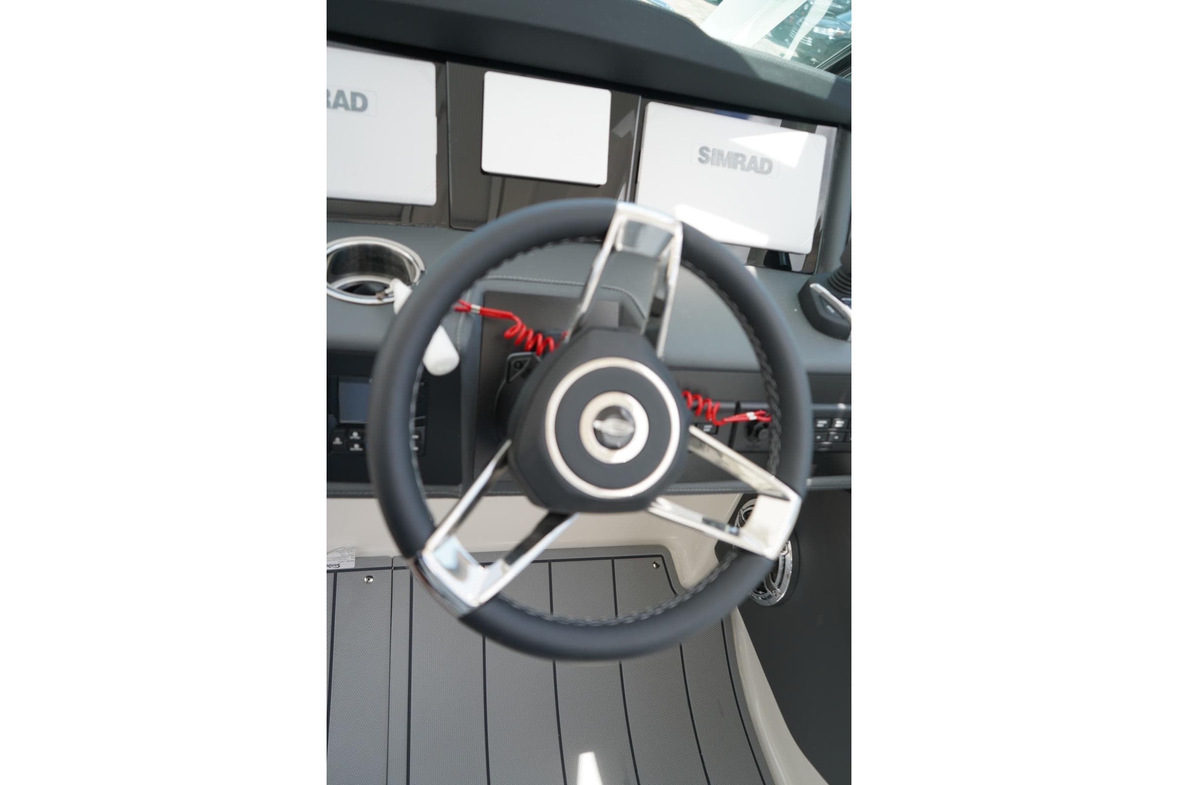 Steering wheel and dashboard of 2026 Chaparral 280 OSX boat with Simrad displays.