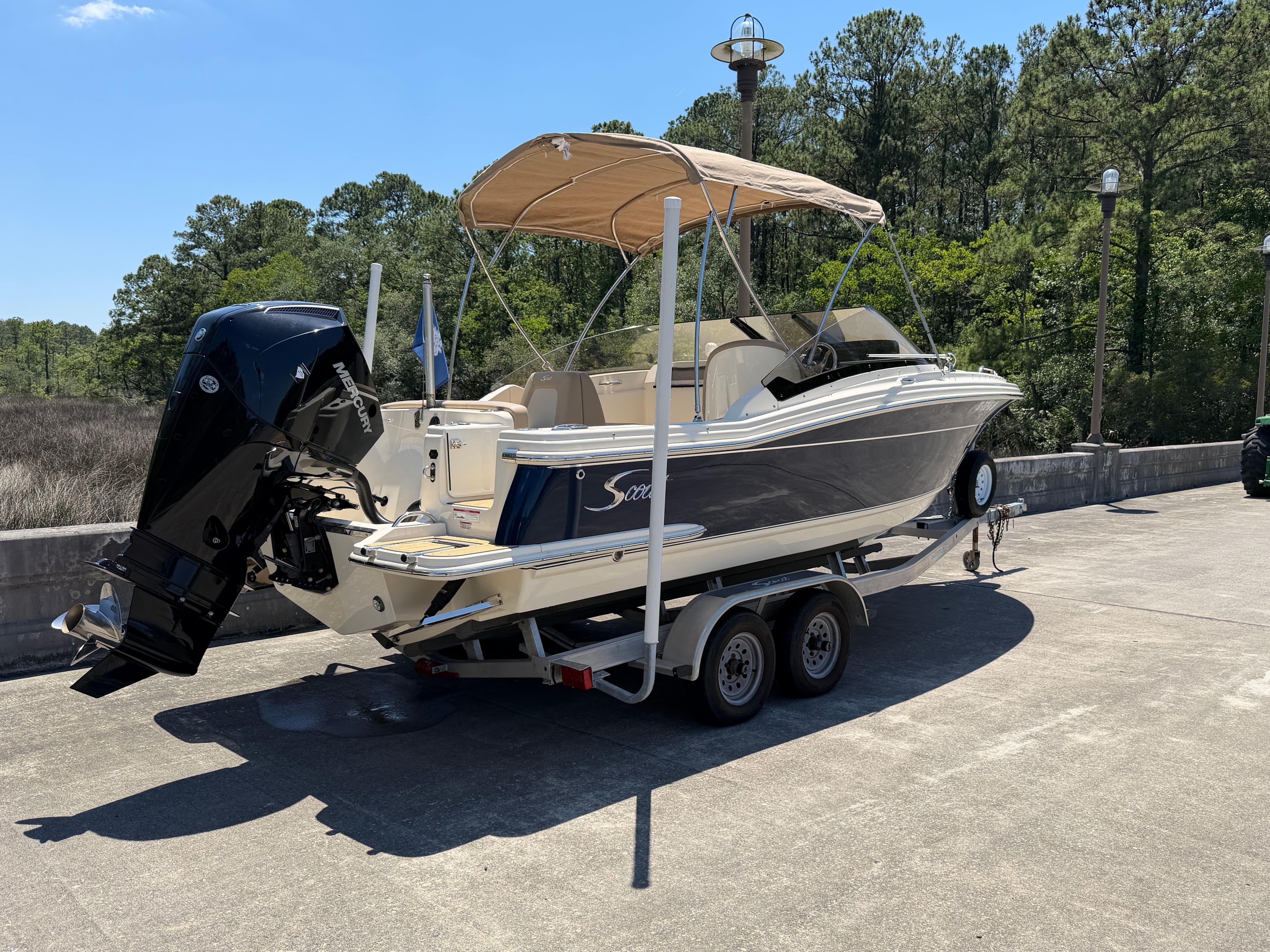 2024 Scout 215 Dorado boat parked on trailer outdoors.