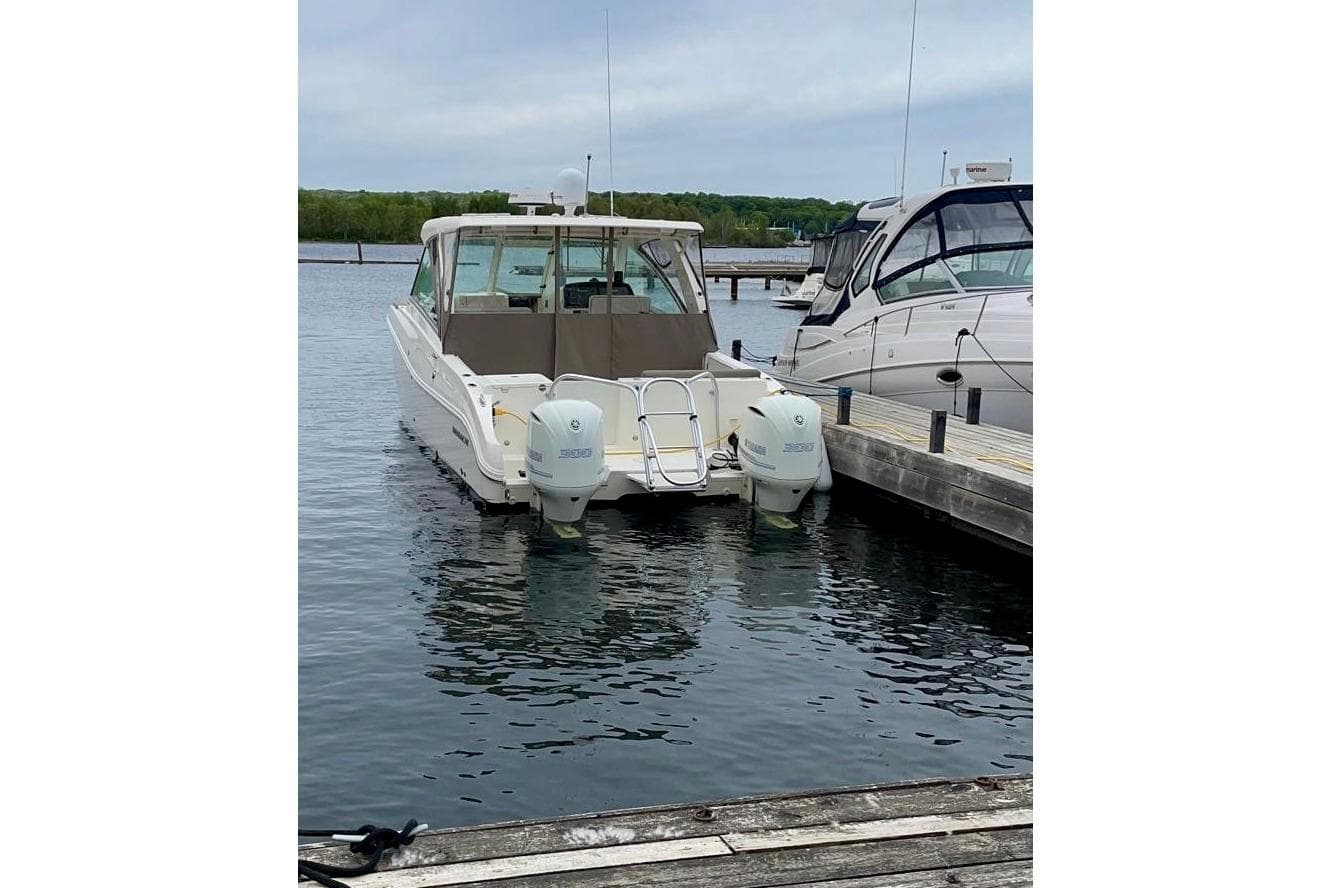 2017 World Cat 320 DC boat docked with twin engines in a marina.