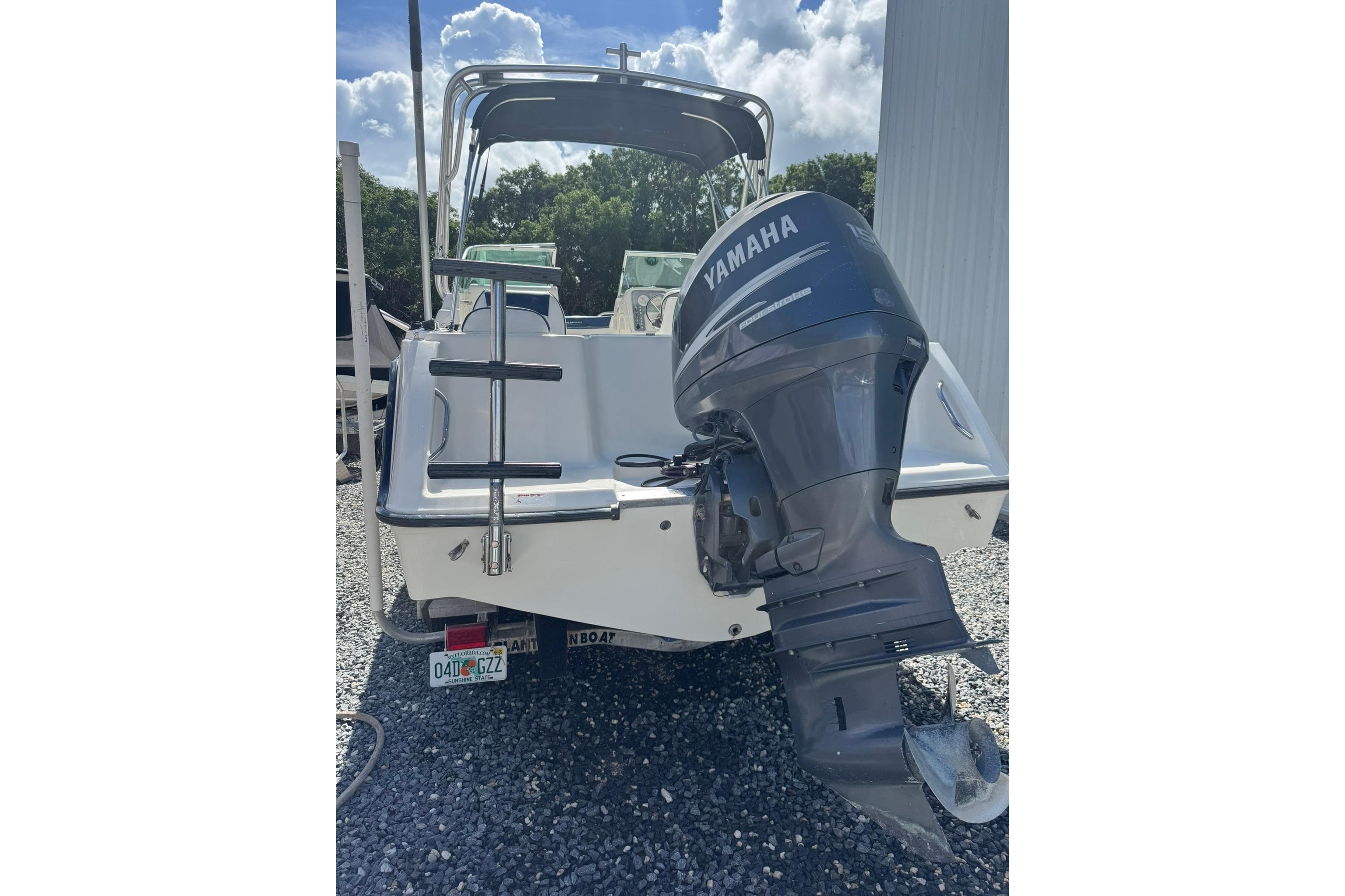 2004 Hydra-Sports Lightning 202 DC boat with Yamaha outboard motor, parked on gravel.