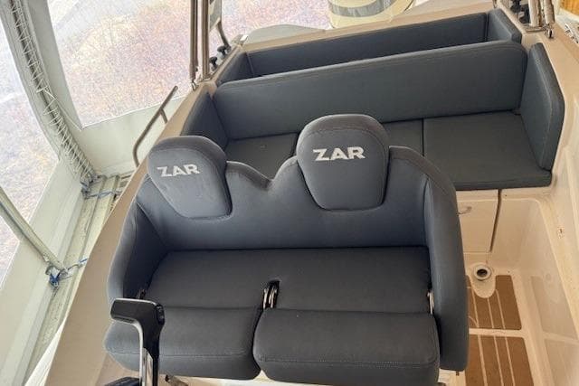 Interior seating of 2020 Zar Formenti 59 SL boat, featuring cushioned seats and steering controls.