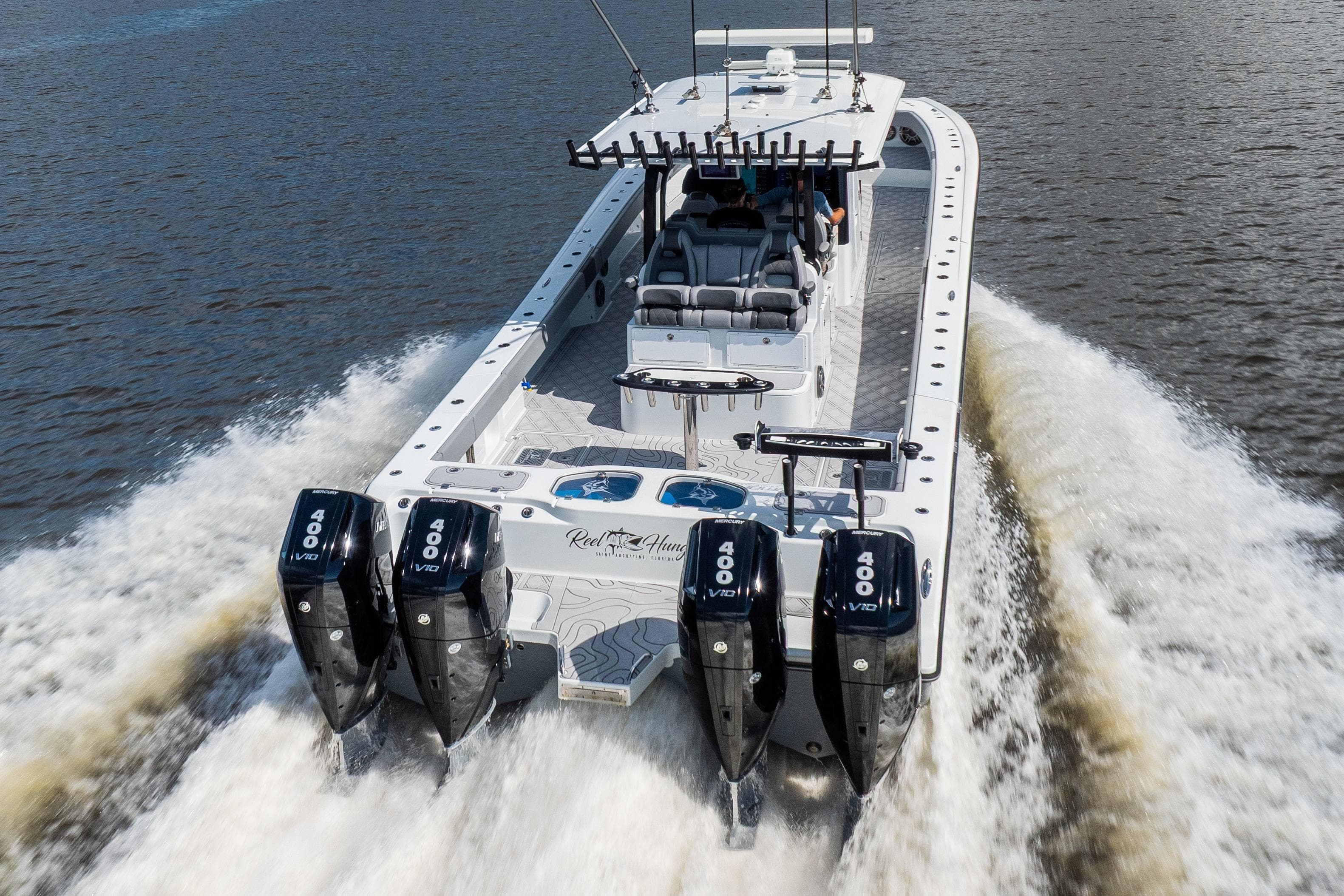2023 Freeman 47 boat with four powerful engines cruising on water.