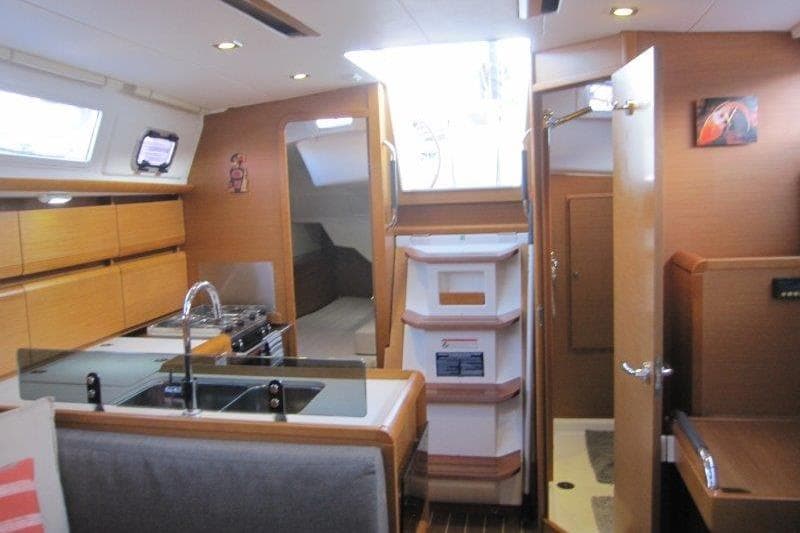 Interior of 2013 Jeanneau 379 sailboat with modern kitchen and cozy cabin space.