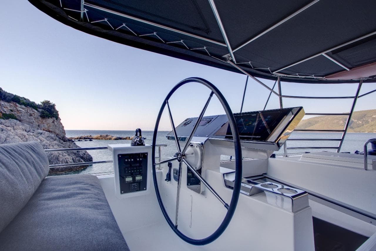 Helm of 2017 Lagoon 620 Essence yacht with ocean view and modern navigation equipment.