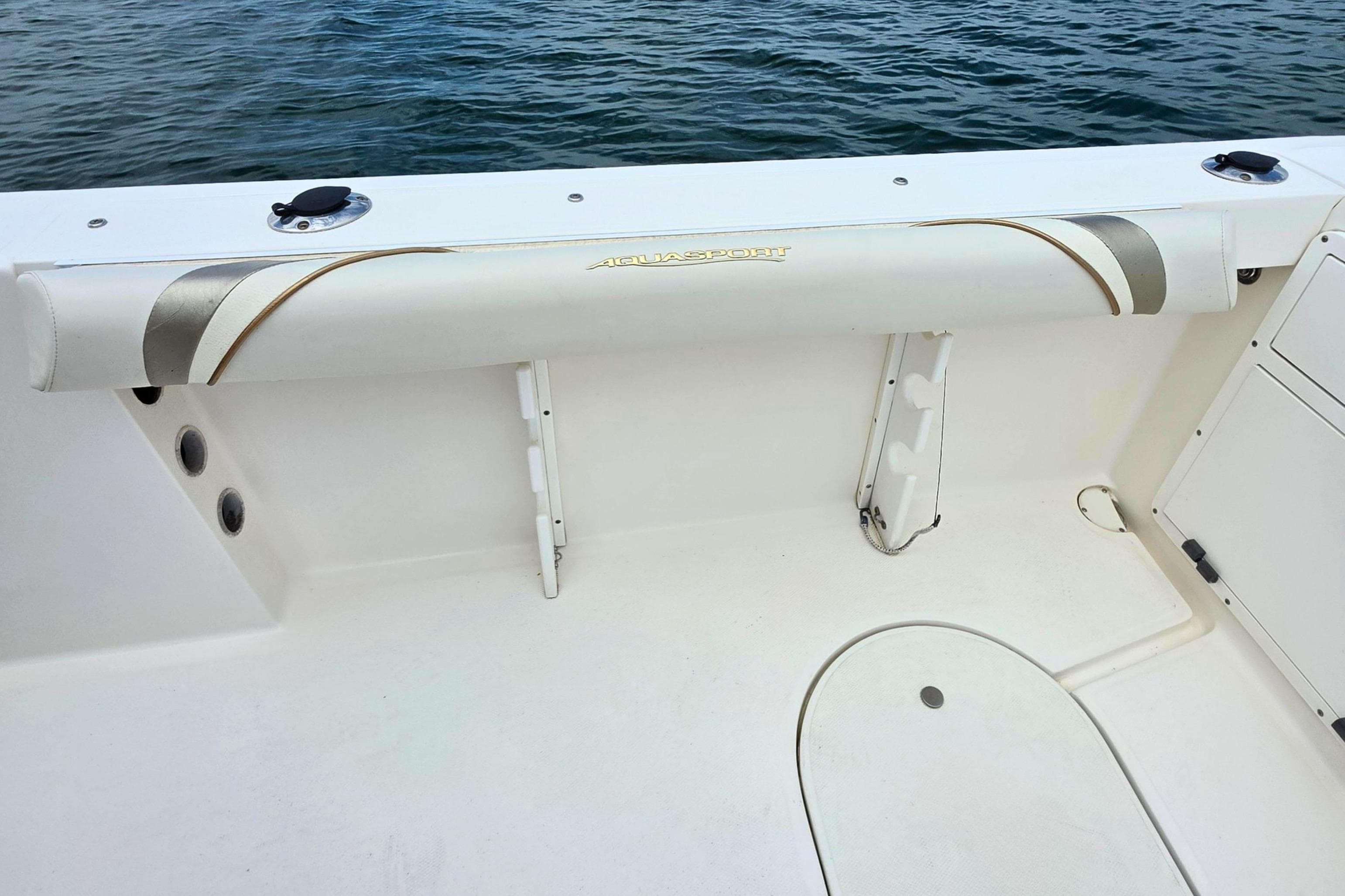 2005 Aquasport 250 Explorer boat interior with rod holders and cushioned seating.