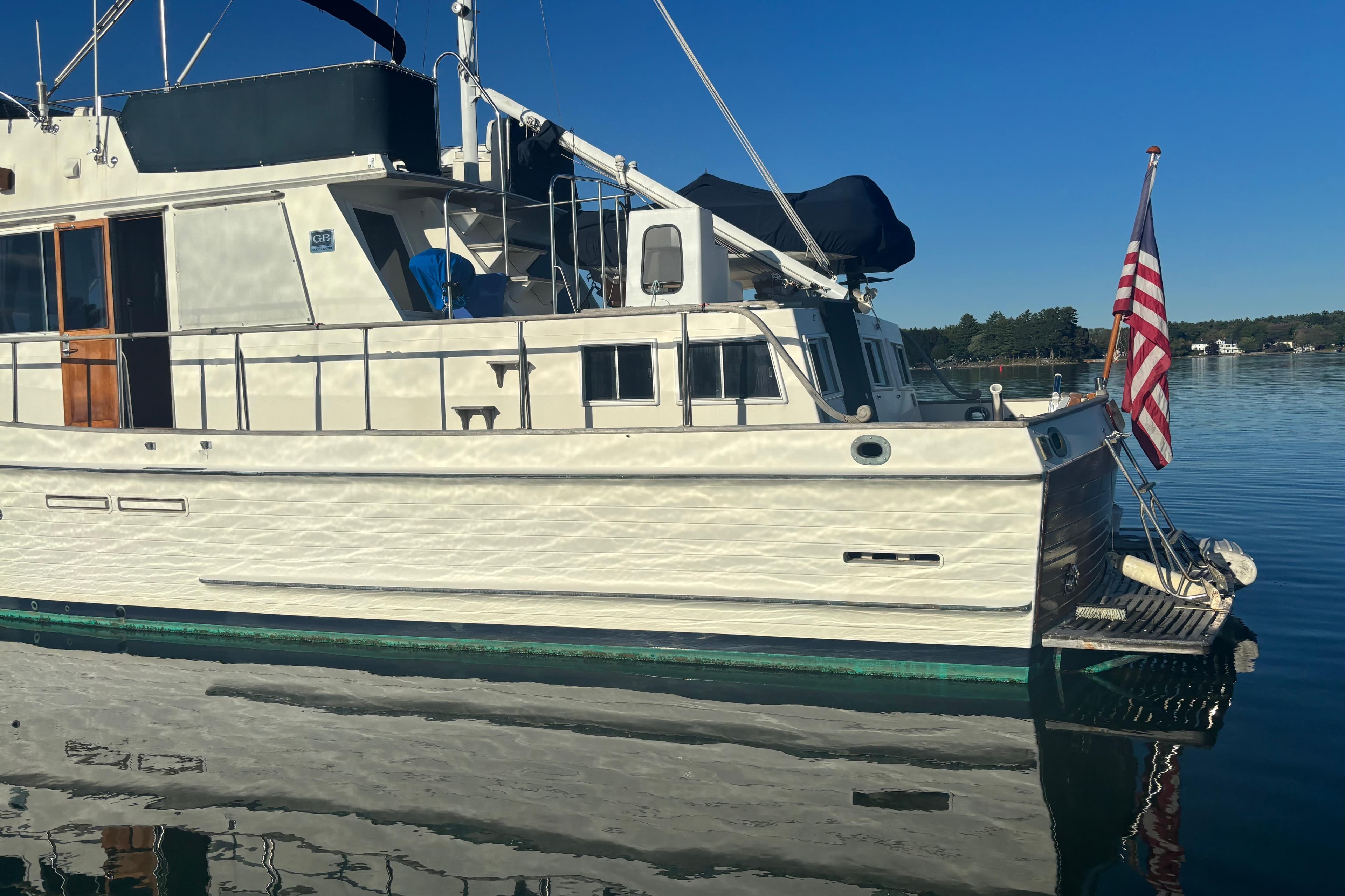 1989 Grand Banks 46 Classic yacht on calm water with American flag.