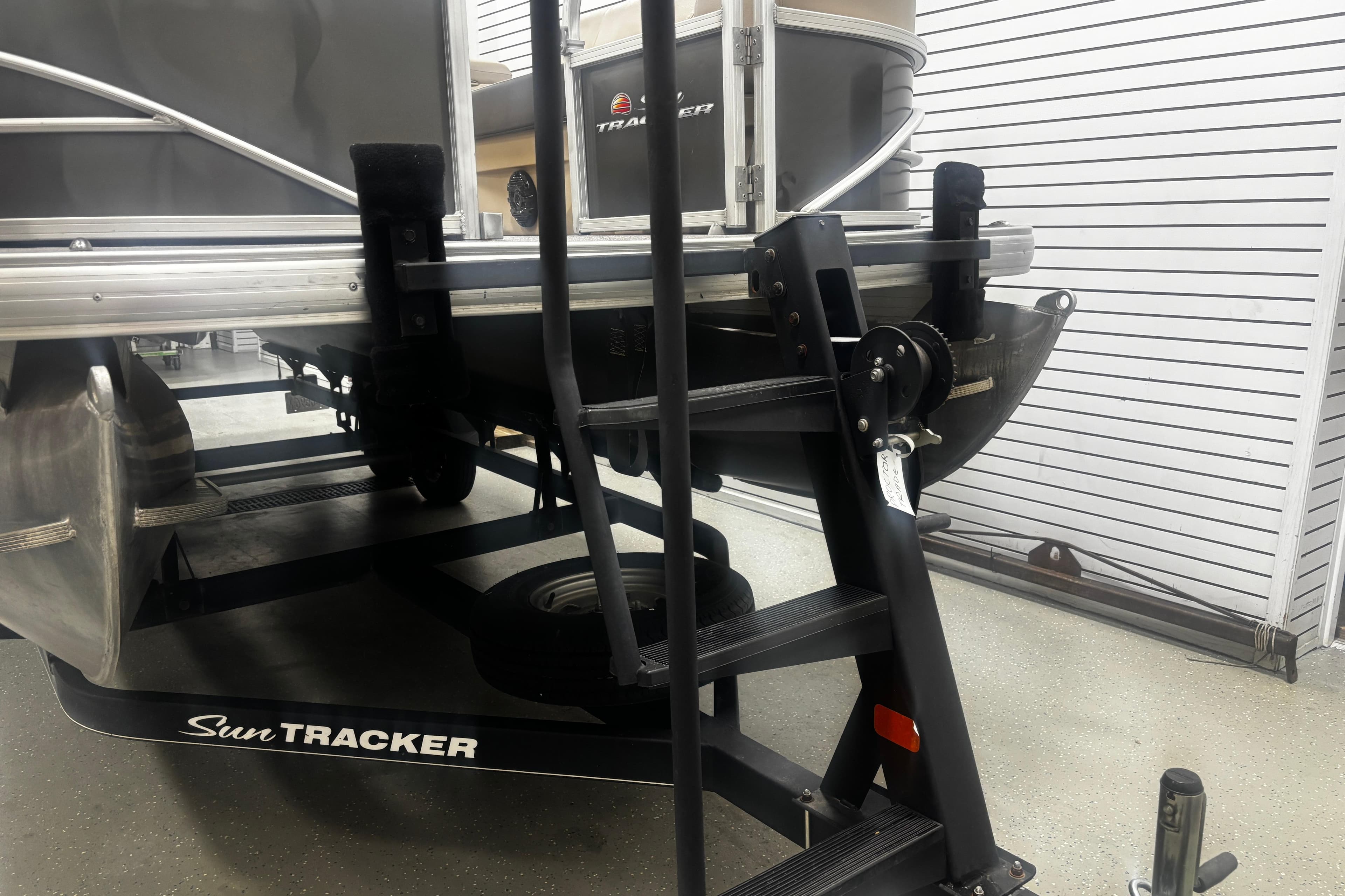 2018 Sun Tracker Party Barge 20 DLX pontoon boat on trailer in showroom.