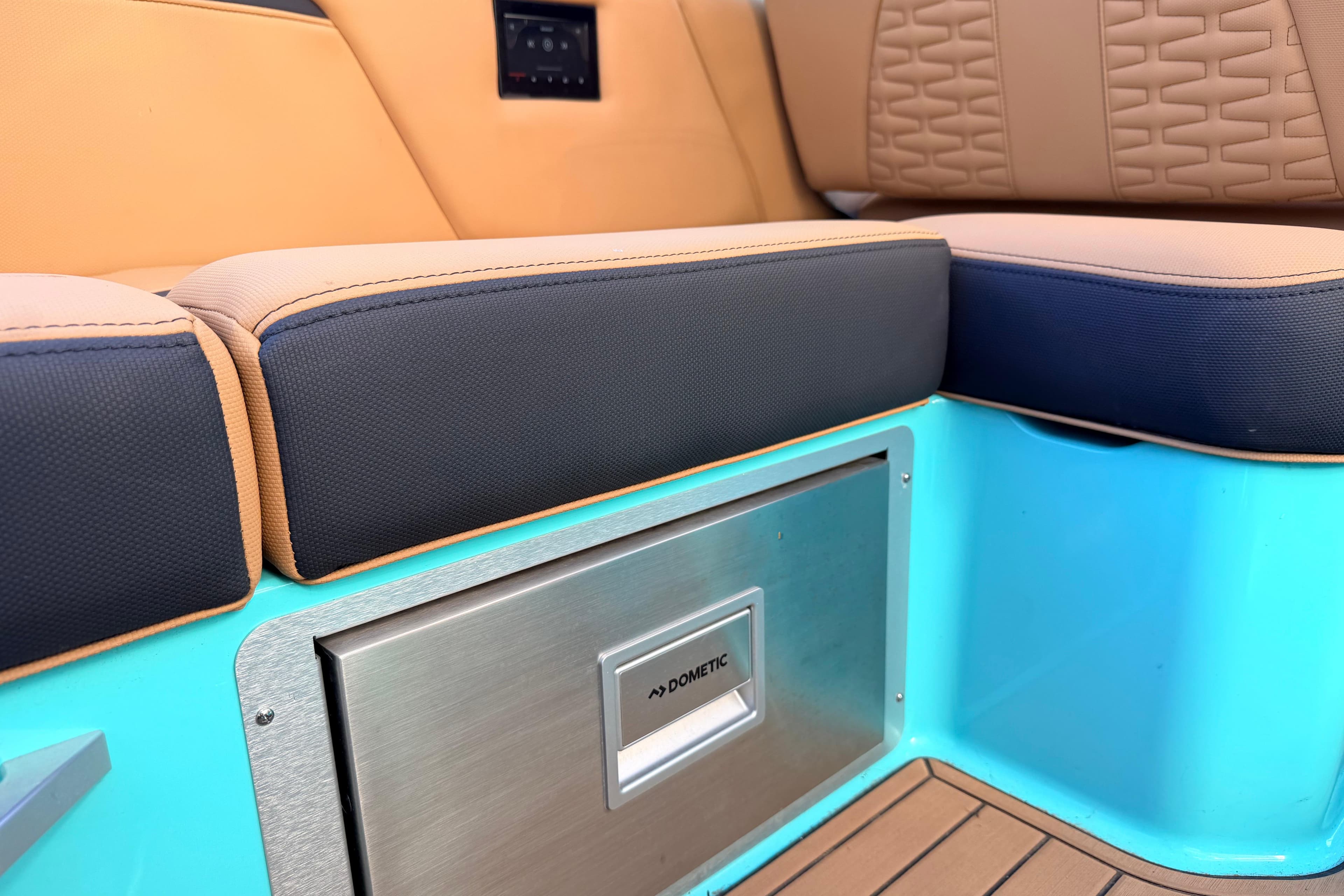 2021 MasterCraft X26 interior with cushioned seating and Dometic cooler.