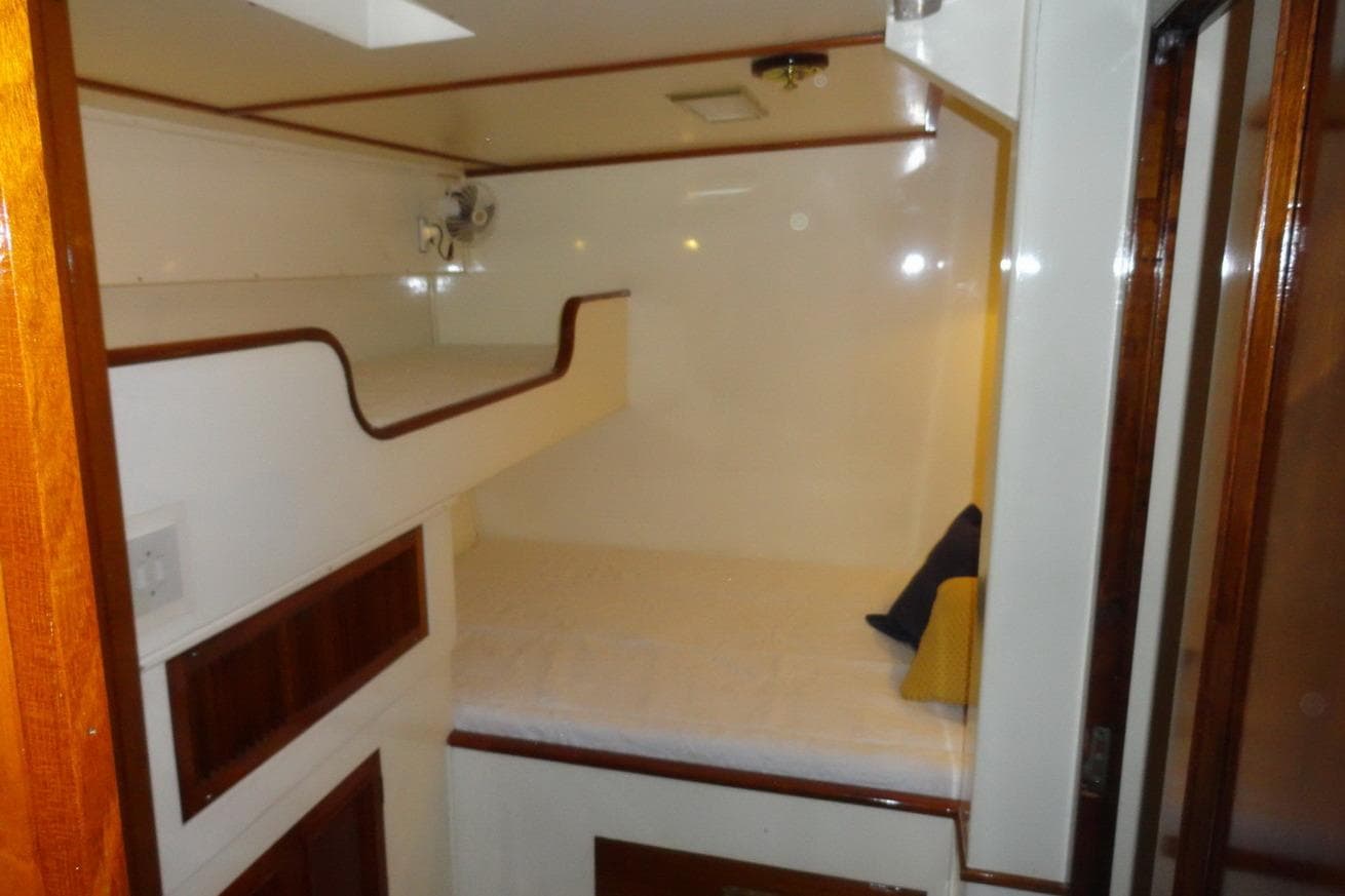 Interior cabin of 1933 Camper & Nicholsons classic wooden ketch, featuring cozy bunk beds.
