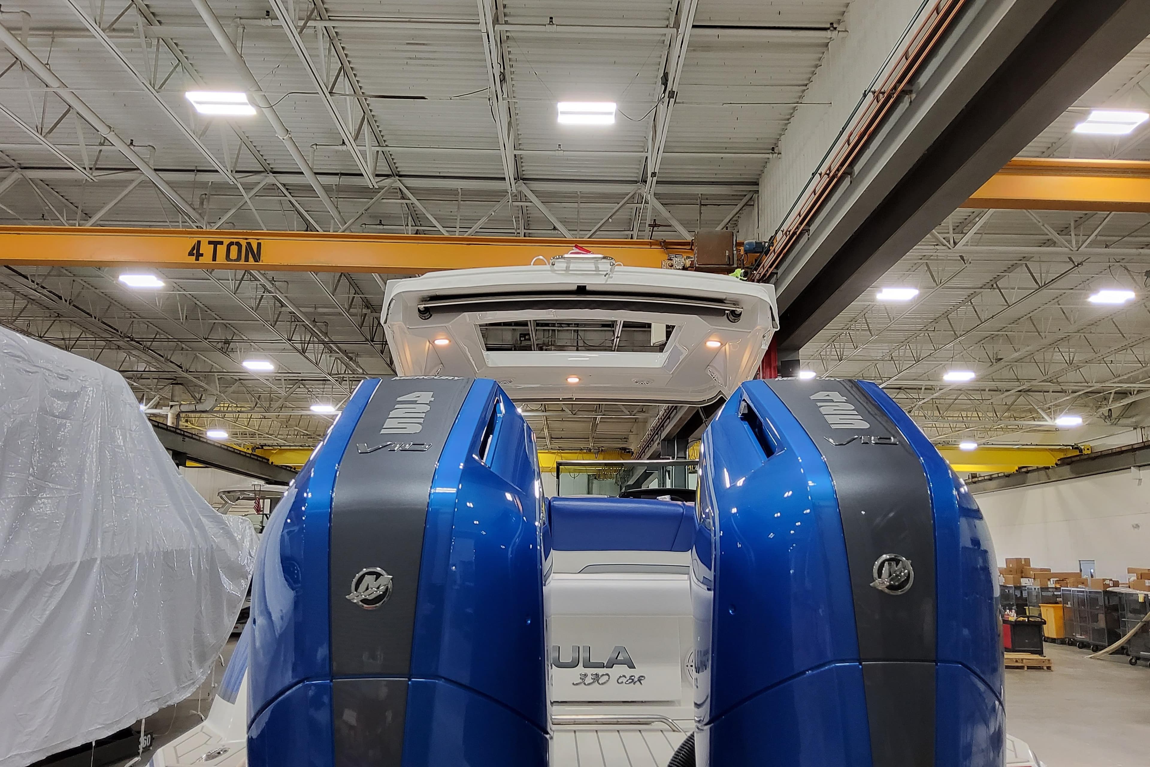 2027 Formula 330 Crossover Bowrider OB with dual outboard engines in a warehouse setting.