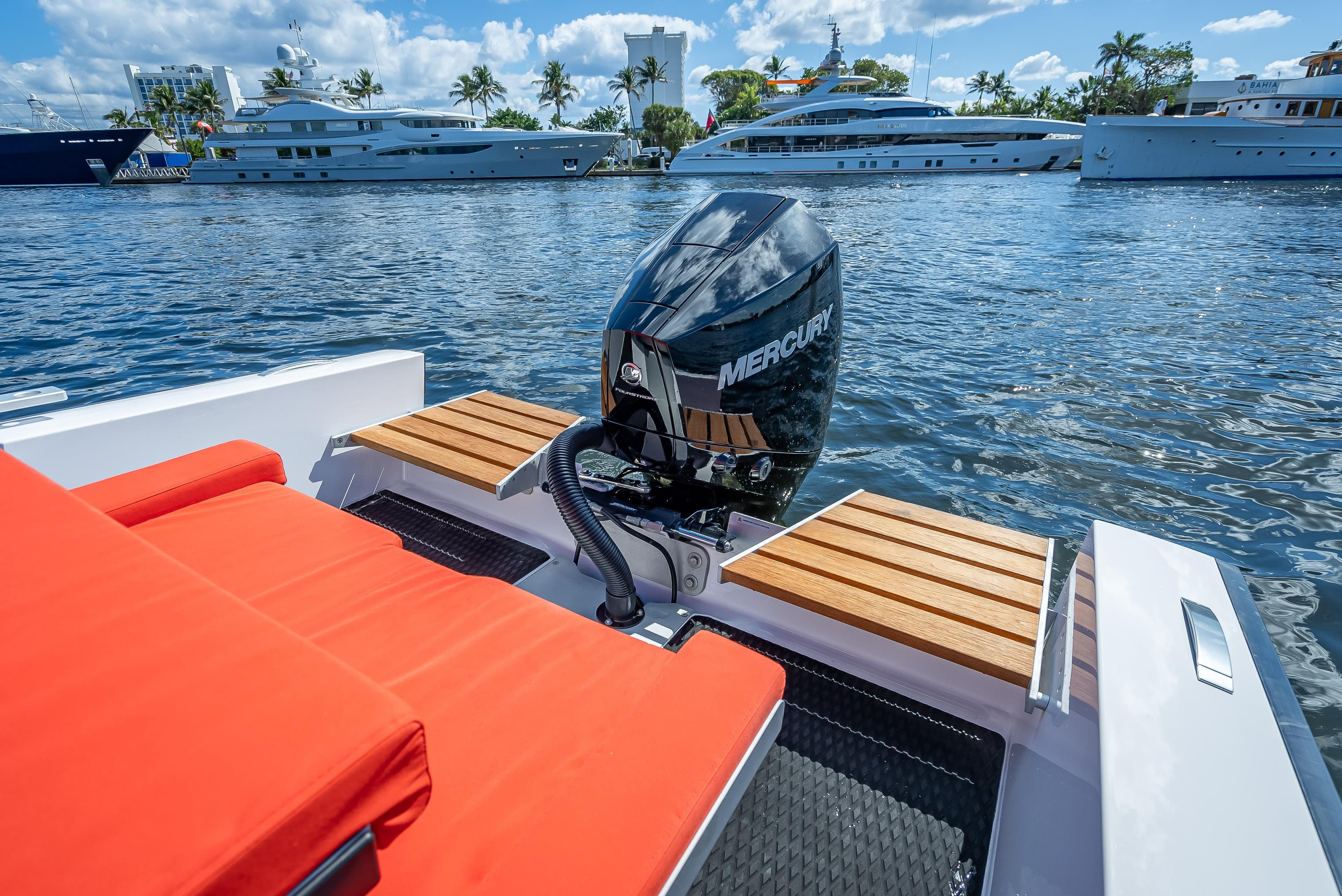 Goldfish 23 Tender 2021 boat with Mercury outboard motor, docked near luxury yachts.