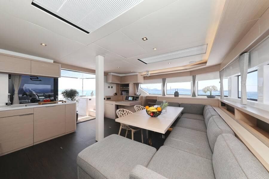 Luxurious interior of 2023 Lagoon 55 yacht with modern kitchen and spacious seating area.