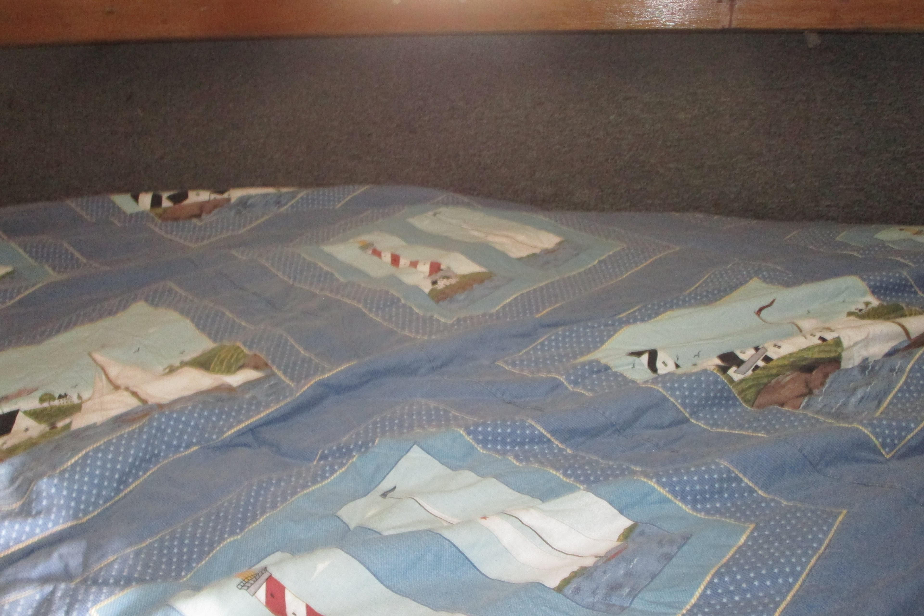 Quilted bedspread with nautical theme inside 1972 Uniflite 36 Sport Sedan boat cabin.